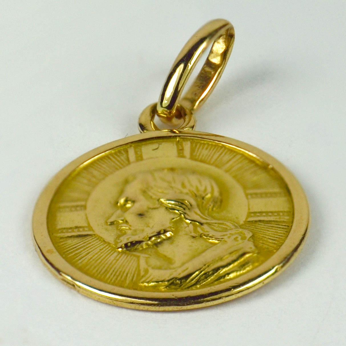 An Italian 18 karat yellow gold charm pendant depicting the head of Jesus on one side and a cross and anchor (indicating faith and hope) with the words 