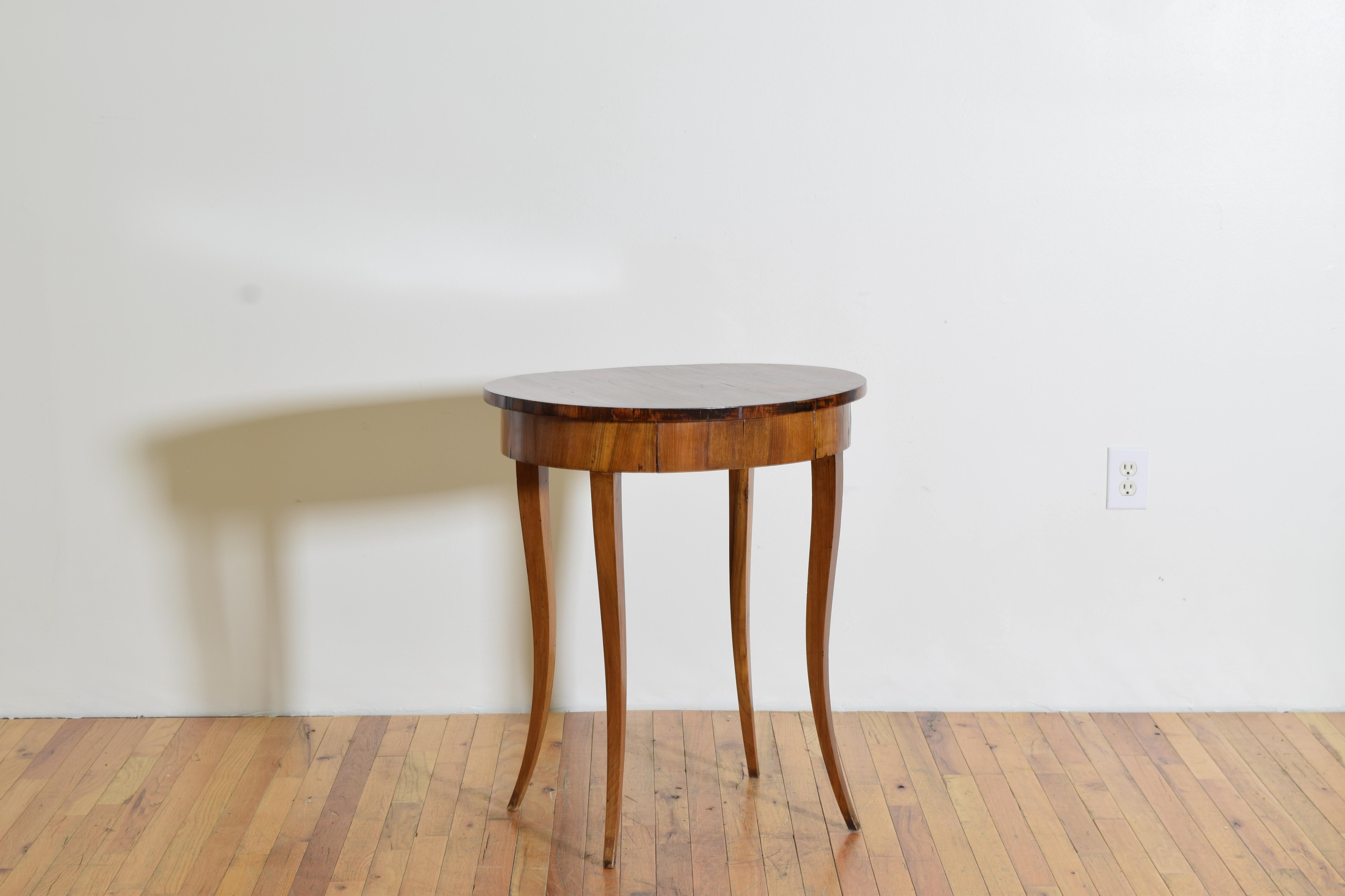 Elegant, lean, and tall this oval table has a large surface space along with a side drawer for storage. The variations of the tones of wood indicating rosewood may have been used for the top with a lighter fruitwood tree used for the legs and apron.
