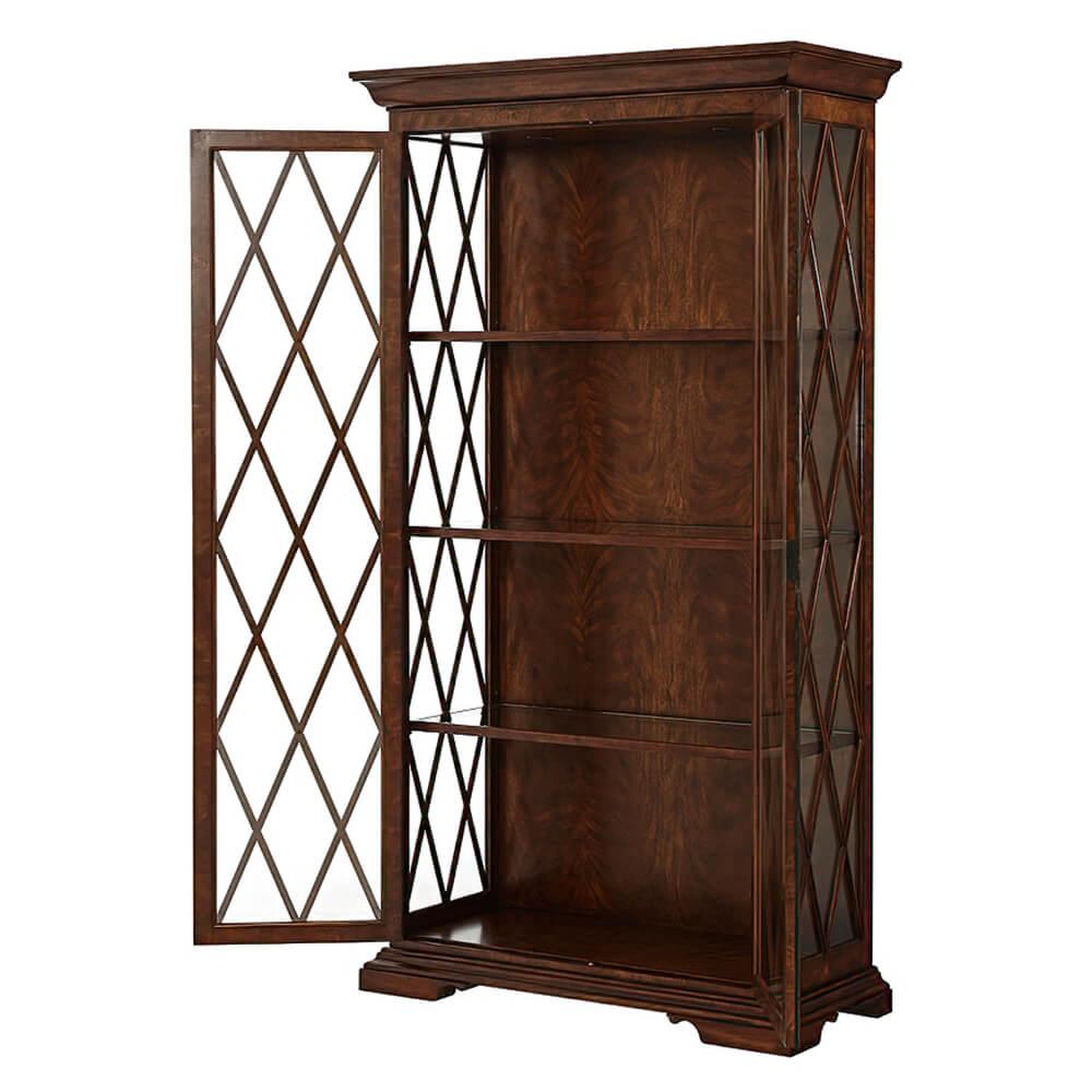 A Classic Italian cerejeira veneered and mahogany display cabinet, the molded cornice above glazed sides and two doors with a trellis astragals enclosing a lit interior with three adjustable wood-framed glass shelves, on bracket feet. 

-