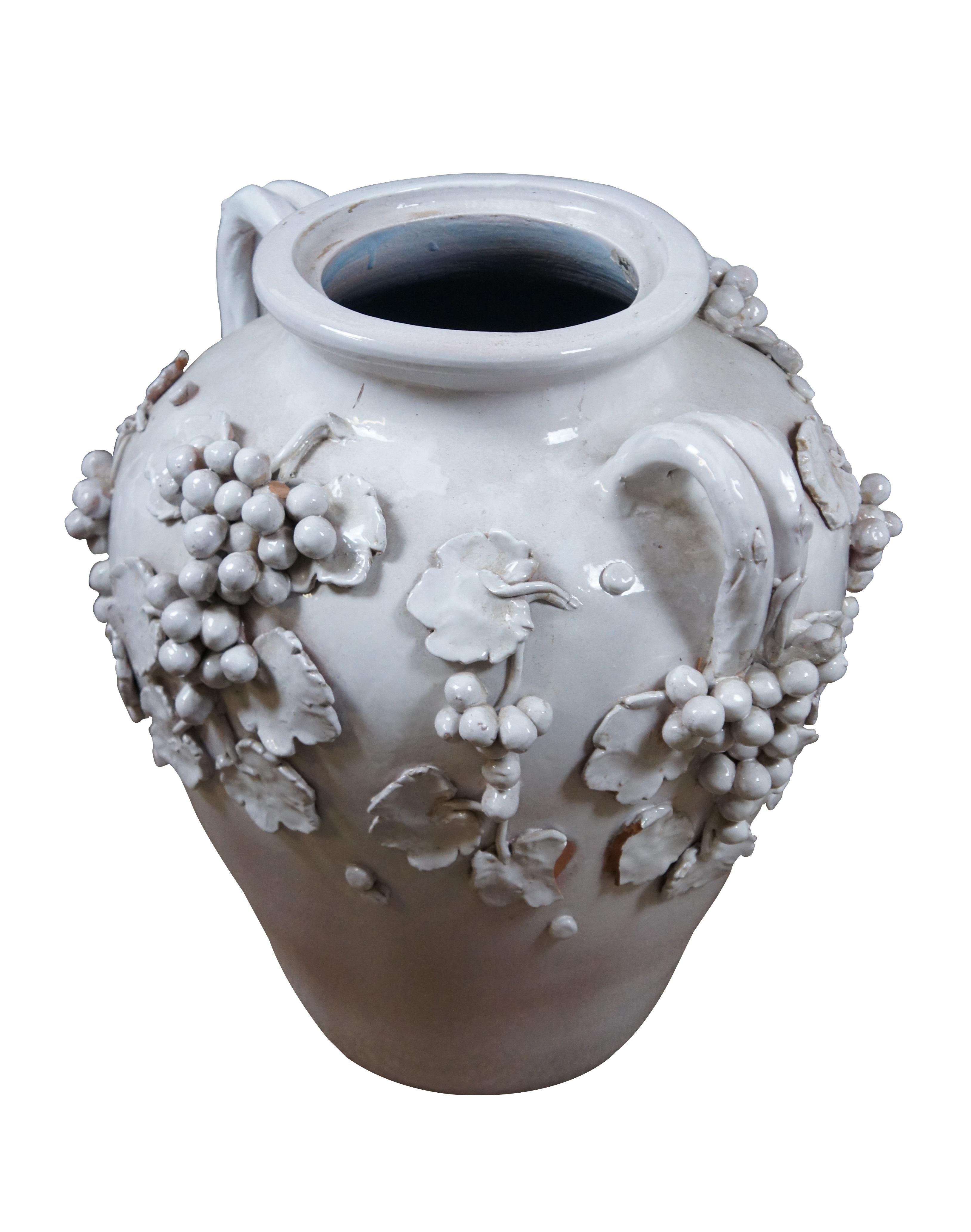 Vaso da terra in terracotta smaltata bianca Dolfi Otello Cottura del XX secolo, molto grande, con due manici e grappoli d'uva e foglie applicati in alto rilievo. Interno smaltato in blu pallido.  Realizzato in Italia per Cottura da Dolfi