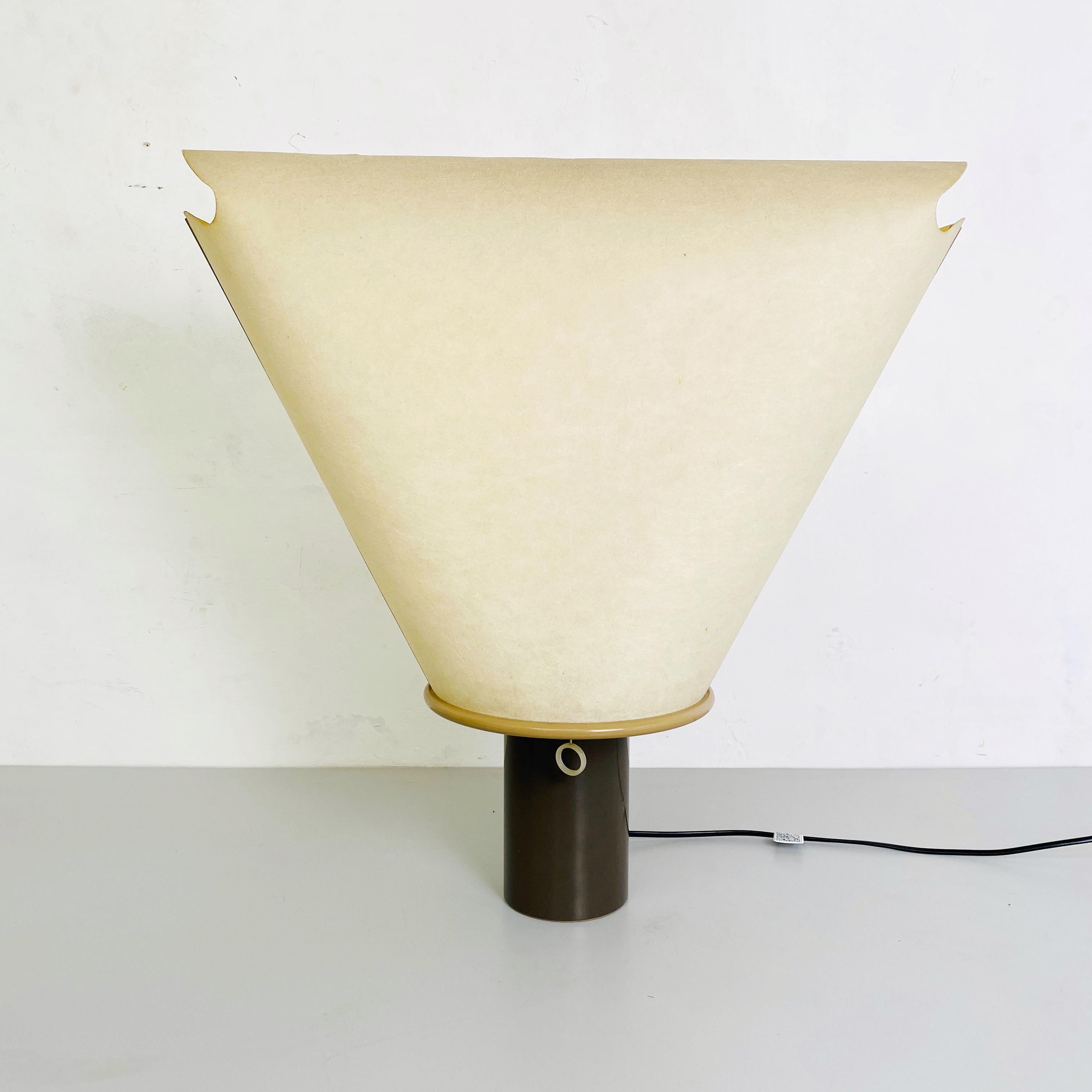 Dolly A 200 table Lamp by King & Miranda Design for Arteluce, 1970s.
Dolly A 200 table lamp is composed of a brown plastic base and irregular lampshade in perforated parchment with chain switch. Produced by Arteluce and project by King & Miranda
