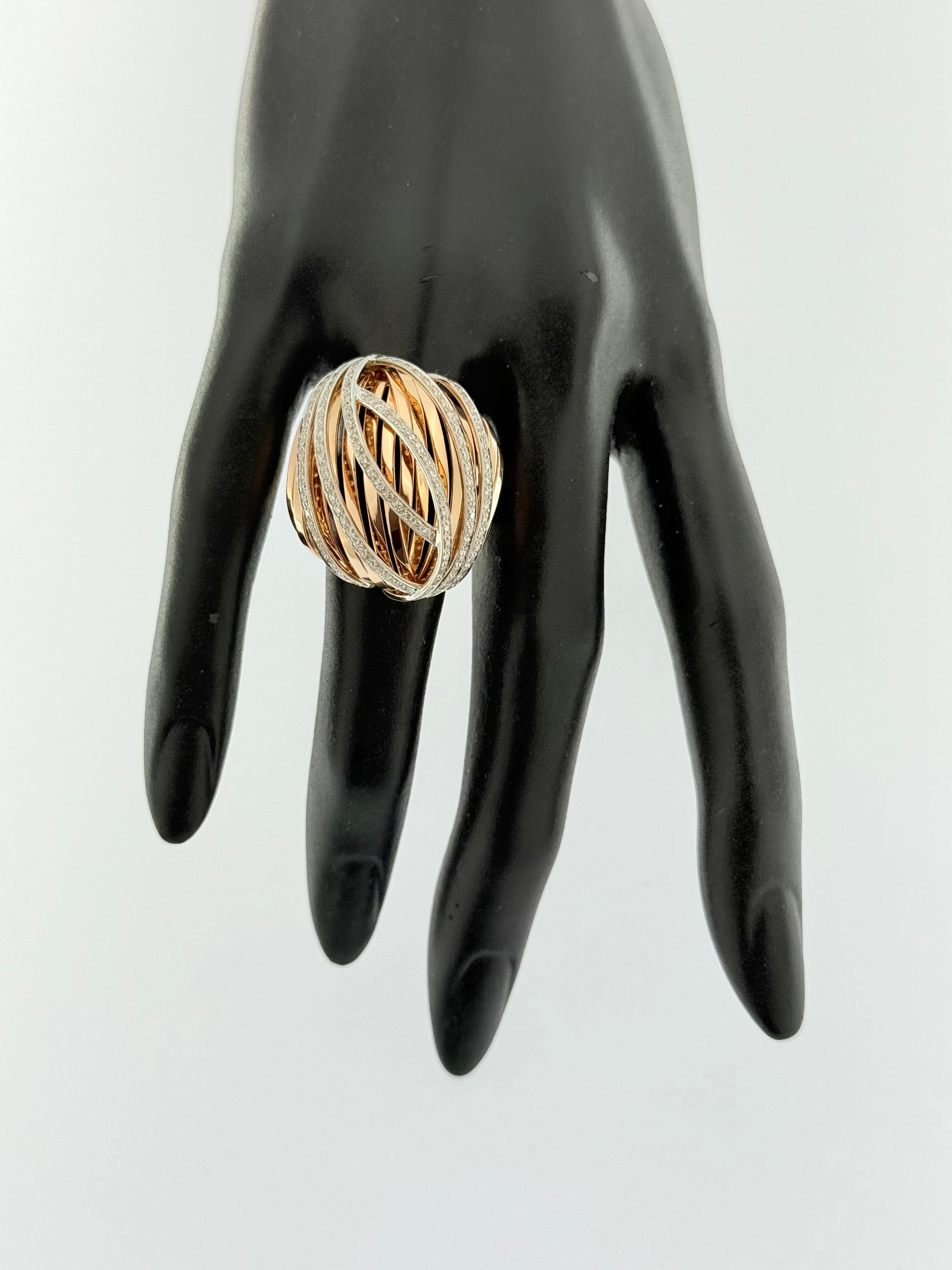 Mesures :
Largeur du plateau : 3 cm, Hauteur : 1,7 cm
Largeur de la bande : 0,6 cm

Cette bague italienne en forme de dôme est une création exquise en or rose et blanc 18kt, qui se distingue par sa forme architecturale audacieuse et son élégance