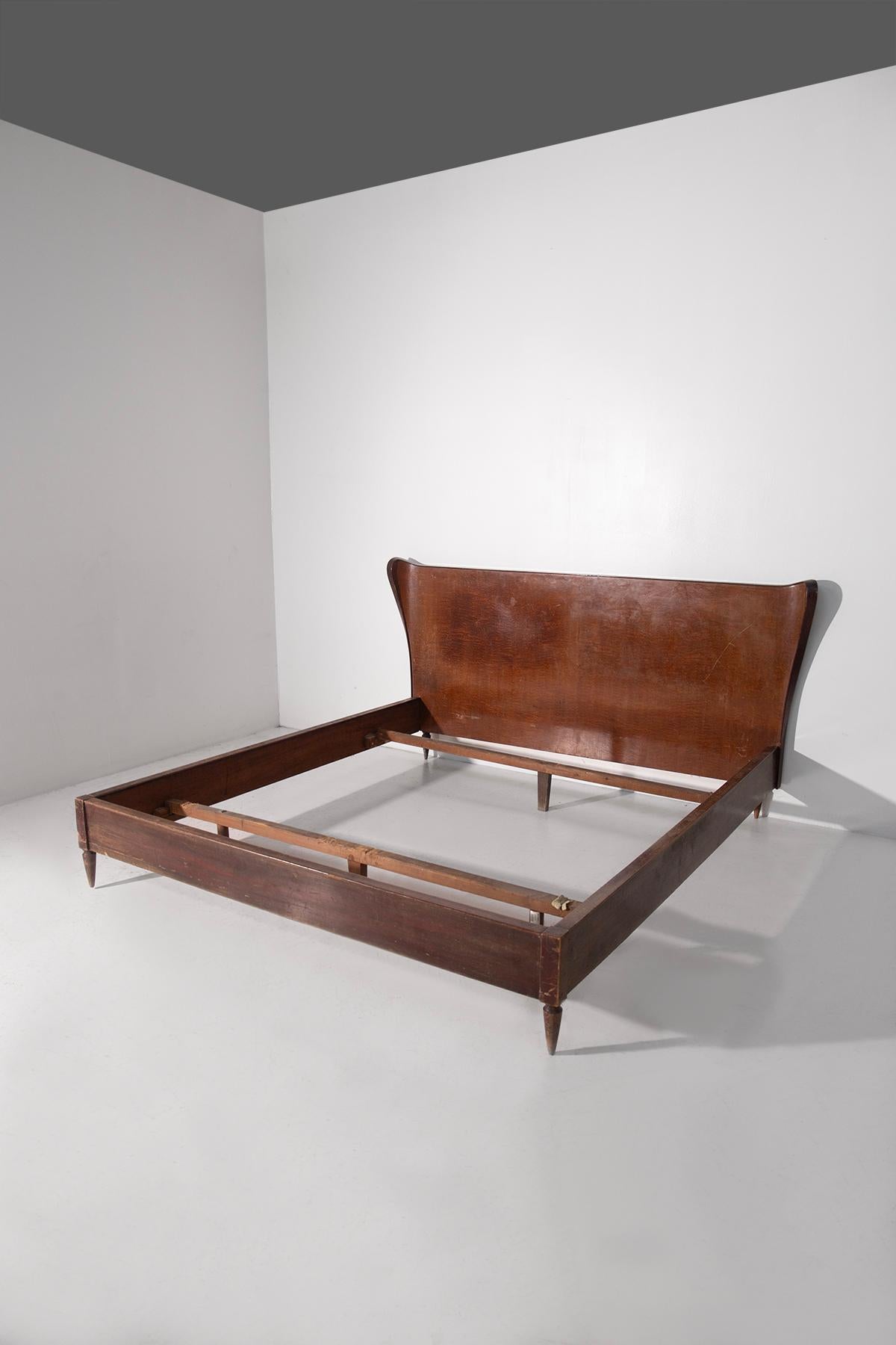 A majestic piece of high-end cabinetry designed by renowned Milanese architect and designer Paolo Buffa, created in the 1950s for the exclusive production of Serafino Arrighi, a leading figure in high-end Italian furniture. This Italian double bed
