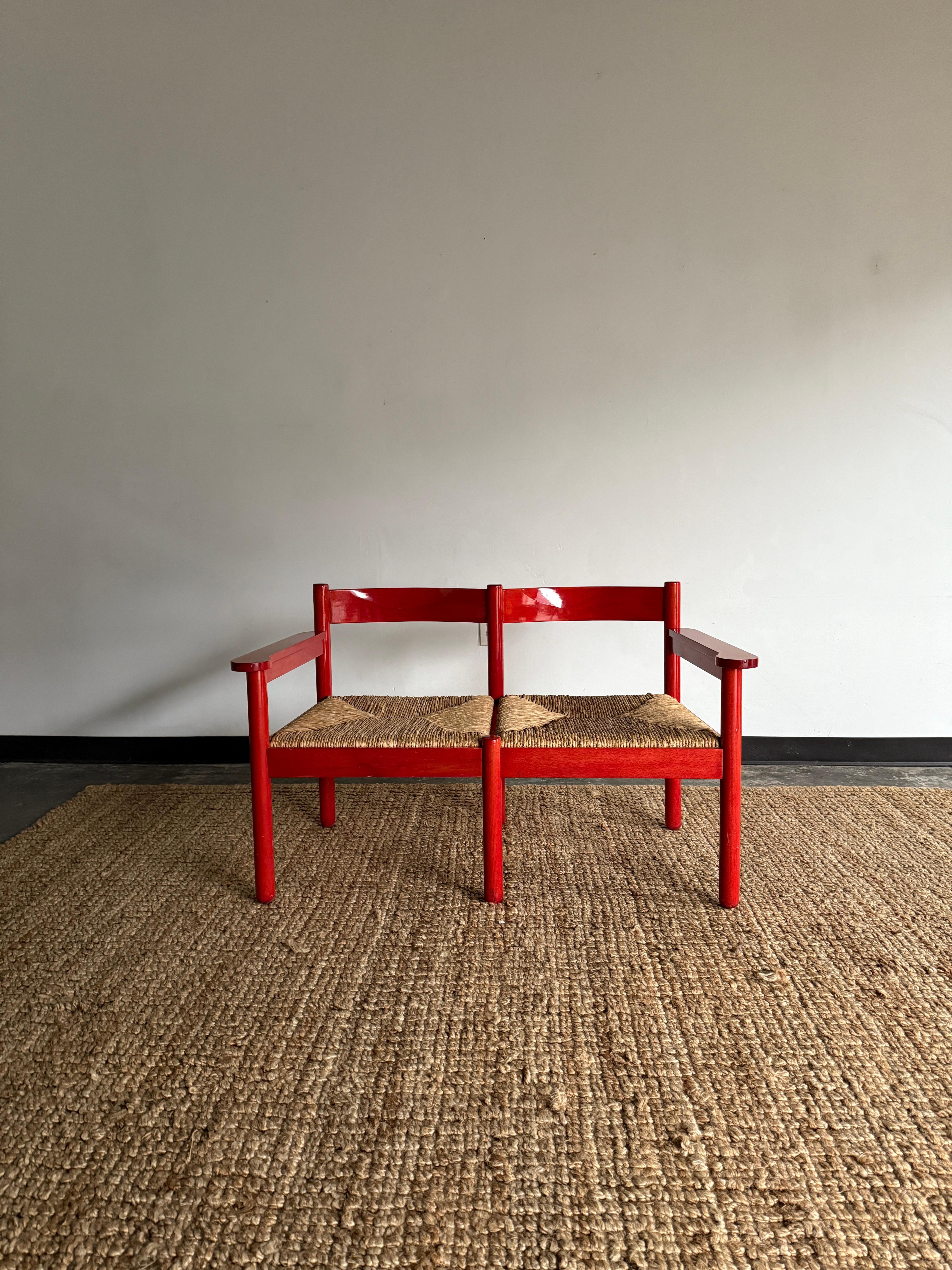 Special double-seat/loveseat/oversized chair comprised of red beech and rush. No damage to rush with minor age-consistent patina on wooden frame. Some minimal signs of red paint on rush where sometime ago, a previous owner may have attempted to