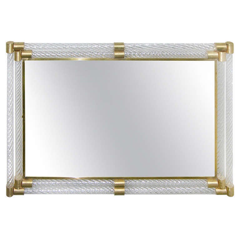 Bespoke Italian organic mirror in Art Deco style, entirely handcrafted, the central plate is edged in brass and surrounded by twisted crystal clear Murano glass pipes in the style of Barovier, encased in handcrafted brass corners, the longer sides