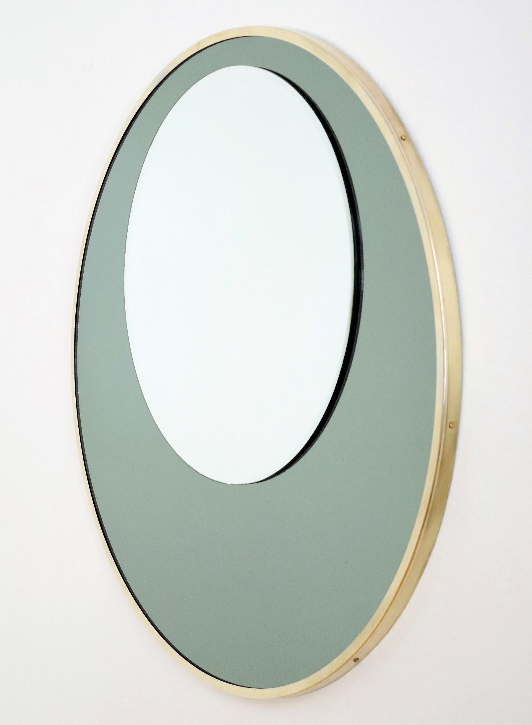 Miroir mural design italien en verre double avec cadre en laiton, années 1970

Magnifique miroir mural ou de console avec deux miroirs ronds de tailles différentes, placés l'un sur l'autre, celui du bas étant en vert mousse. 
Le miroir est doté d'un