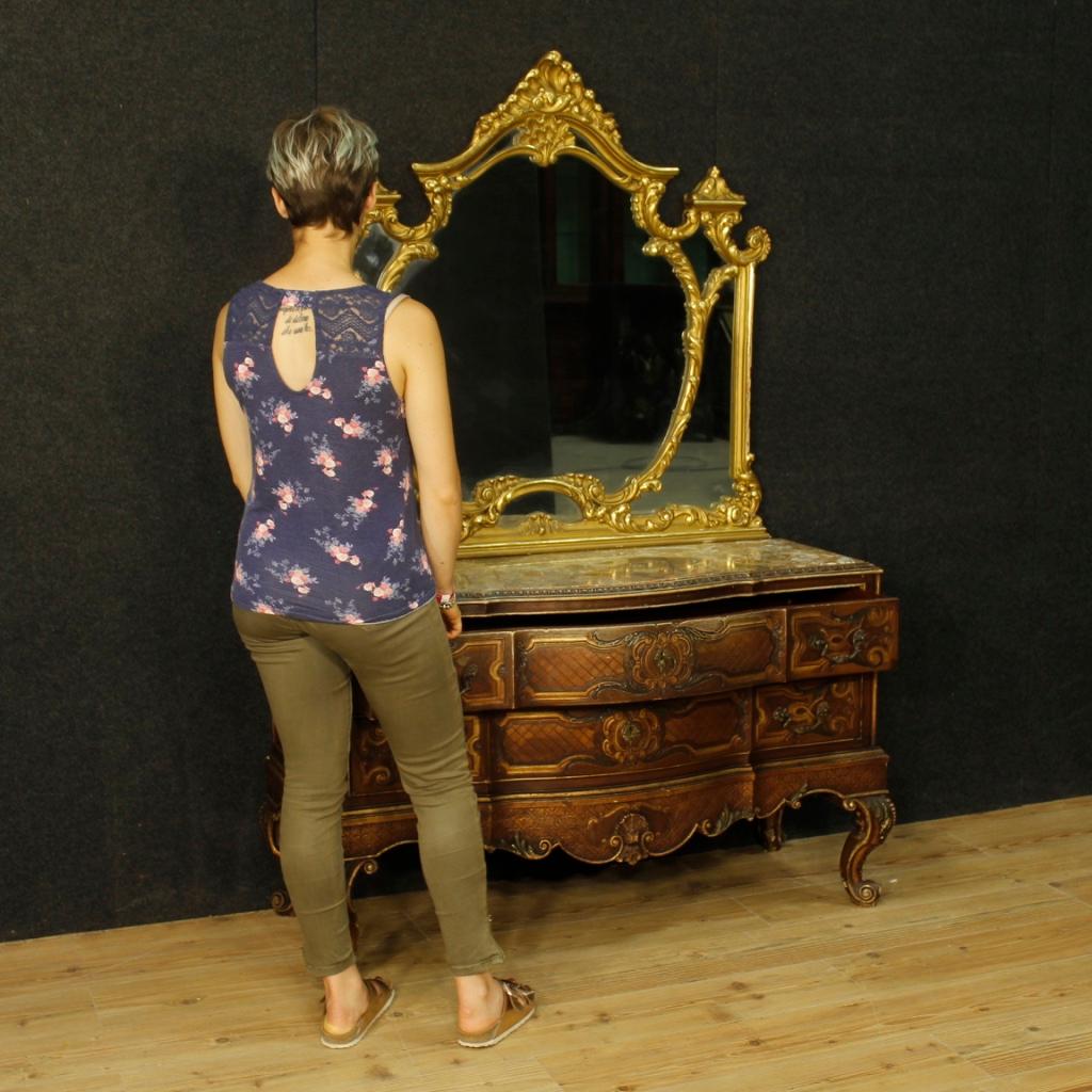Italian dresser with mirror from 20th century. Chest of drawers in carved, lacquered and gilded wood with two drawers of good capacity and service. Top in recessed marble to be restored. Sculpted and gilded wooden mirror of beautiful decoration.