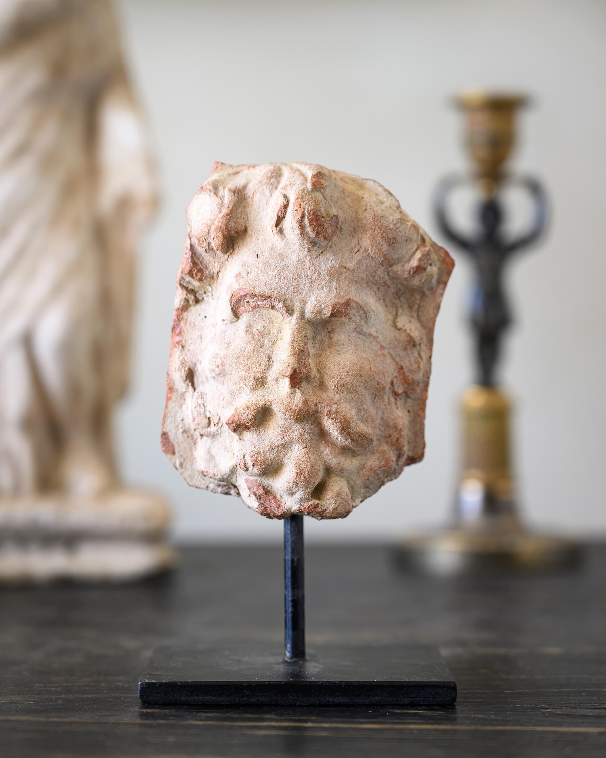 Italian early 18th century terracotta fragment of an face mounted on stand. Ca 1690 - 1710 Italy.  Measurements with stand H 15 W 9 D 6.6 cm.