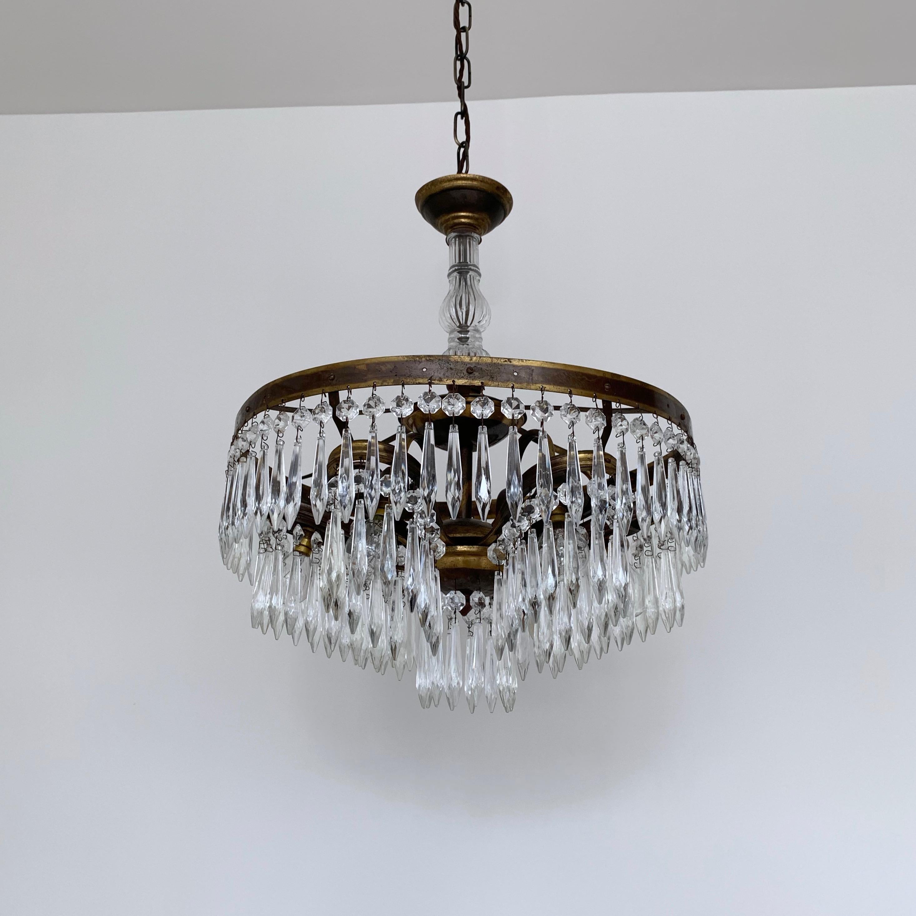 These continental waterfall chandeliers are made to order. Originating from early 1900s Italy. It has a delicate frame with central glass stem and six lower petal tiers all adorned with icicle drops. The lamps face down within each lower petal tier