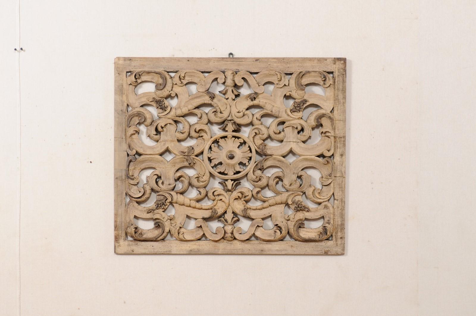 An Italian pierce-carved wooden wall plaque from the early 19th century. This antique architectural wall ornament from Italy has a nearly square shape and has been elaborately hand carved with a beautiful pierced scrolling acanthus leaf motif with