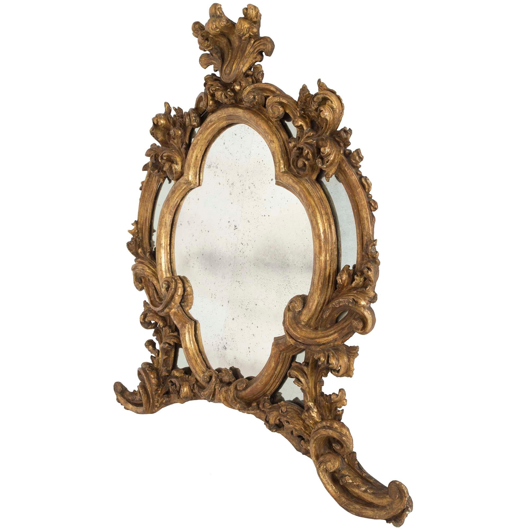 A wonderful Italian early 19th century Baroque st. double framed Mecca mirror. The mirror is raised by wonderful scrolled feet with richly carved foliate movements which extend up each side. The original central mirror plate is framed within a most