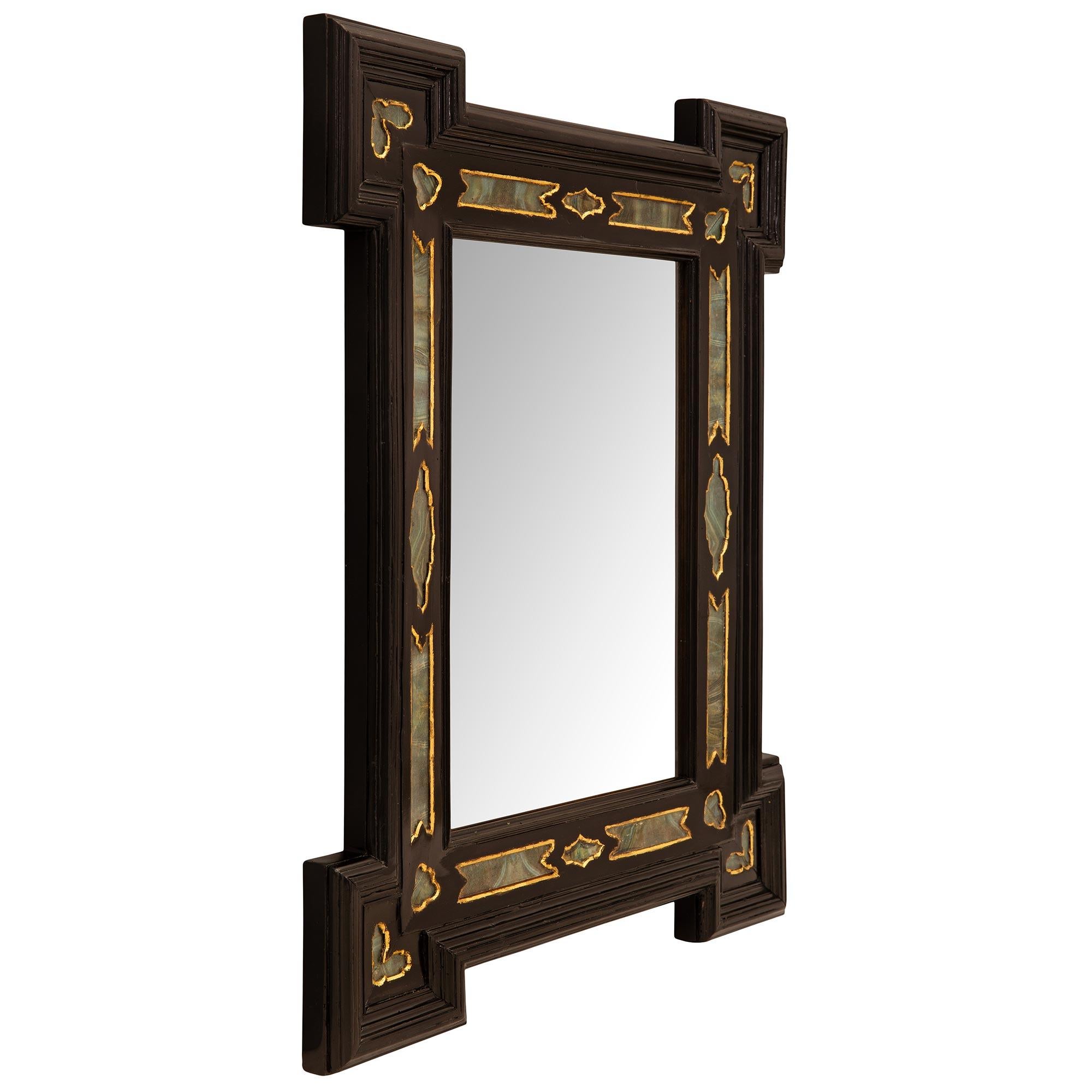 A beautiful and most decorative Italian early 19th century Baroque st. ebonized fruitwood and Verre Églomisé mirror. The mirror retains its original mirror plate set within a fine wrap around mottled border. The frame displays stunning wonderfully