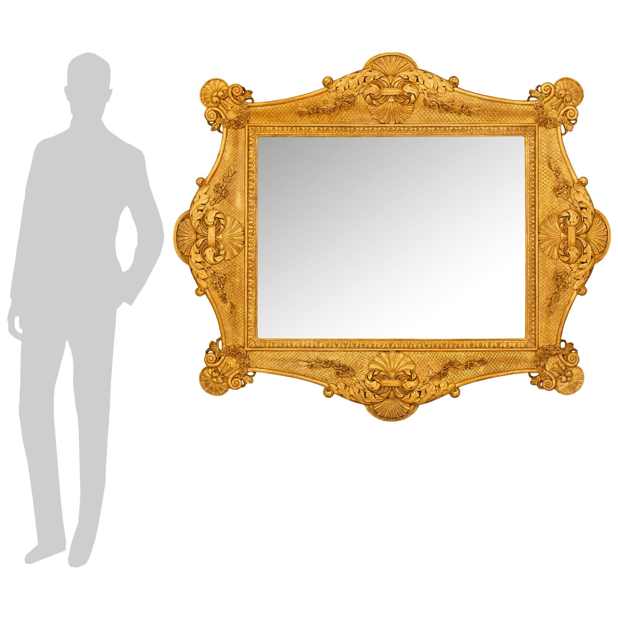 A stunning and most decorative Italian early 19th century Baroque st. Giltwood mirror. The mirror retains its original mirror plate framed within a fine straight mottled border with a wrap around foliate band. The frame displays elegant and most