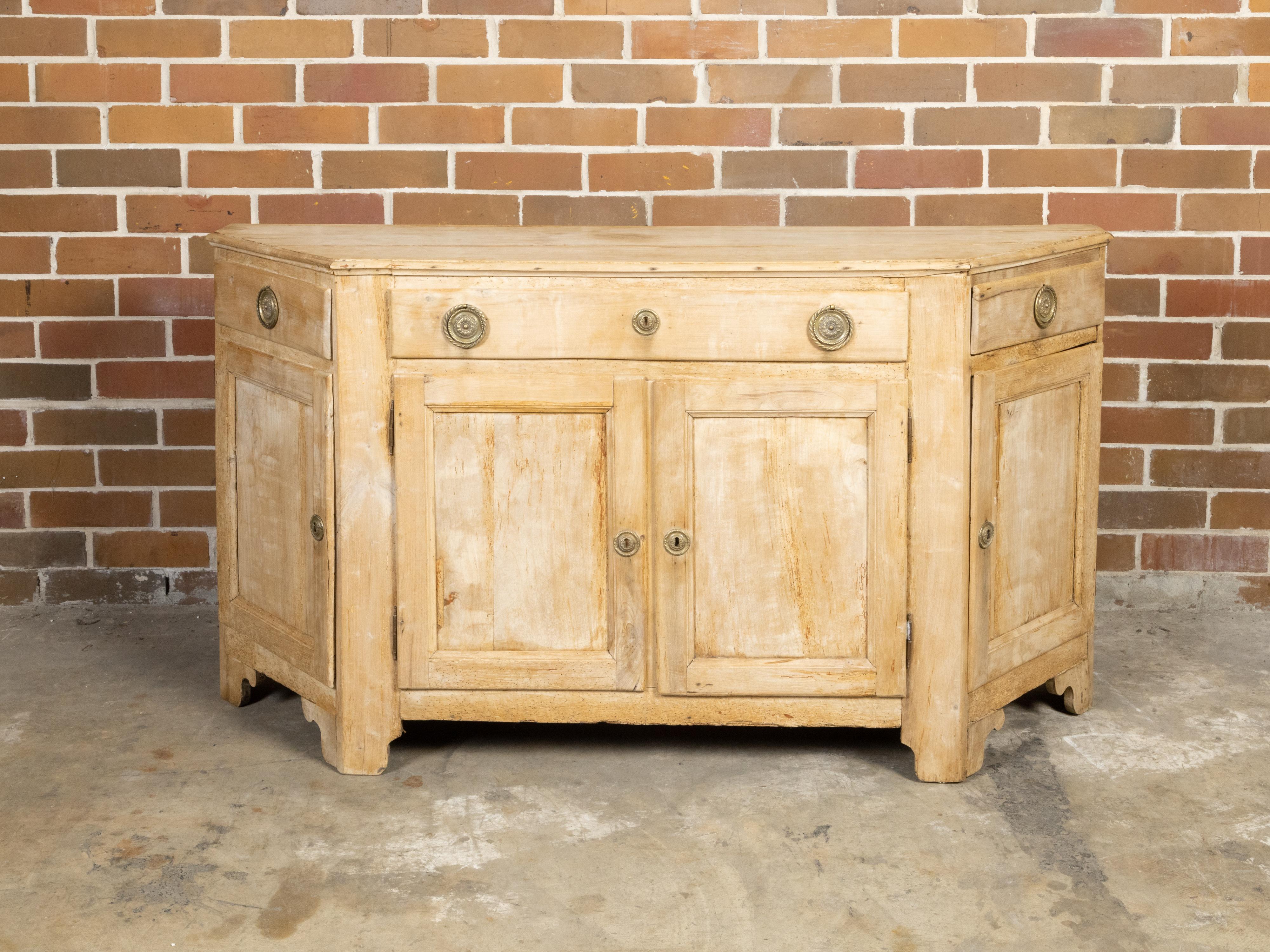 An Italian bleached wood credenza from the early 19th century, with canted sides, three drawers over four doors. Created in Italy during the early years of the 19th century, this stunning credenza features a linear silhouette perfectly complimented