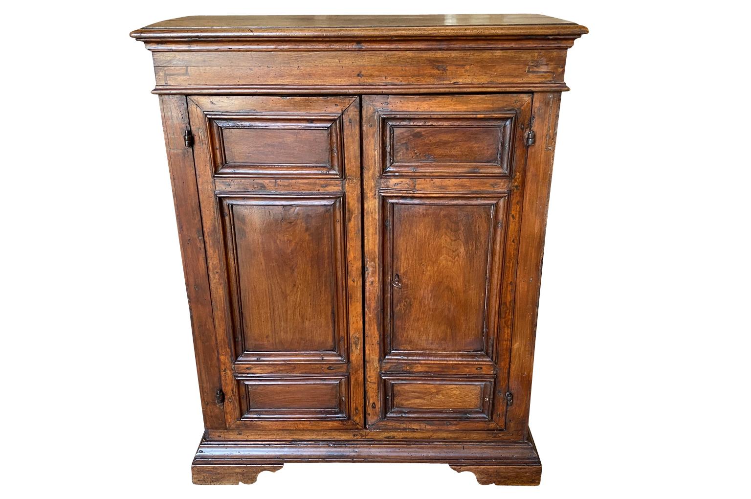 A very handsome early 19th century Credenzino from the Lombardy region of Italy. Soundly constructed from beautiful walnut a shaped top above double doors, interior shelving raised on bracket feet.