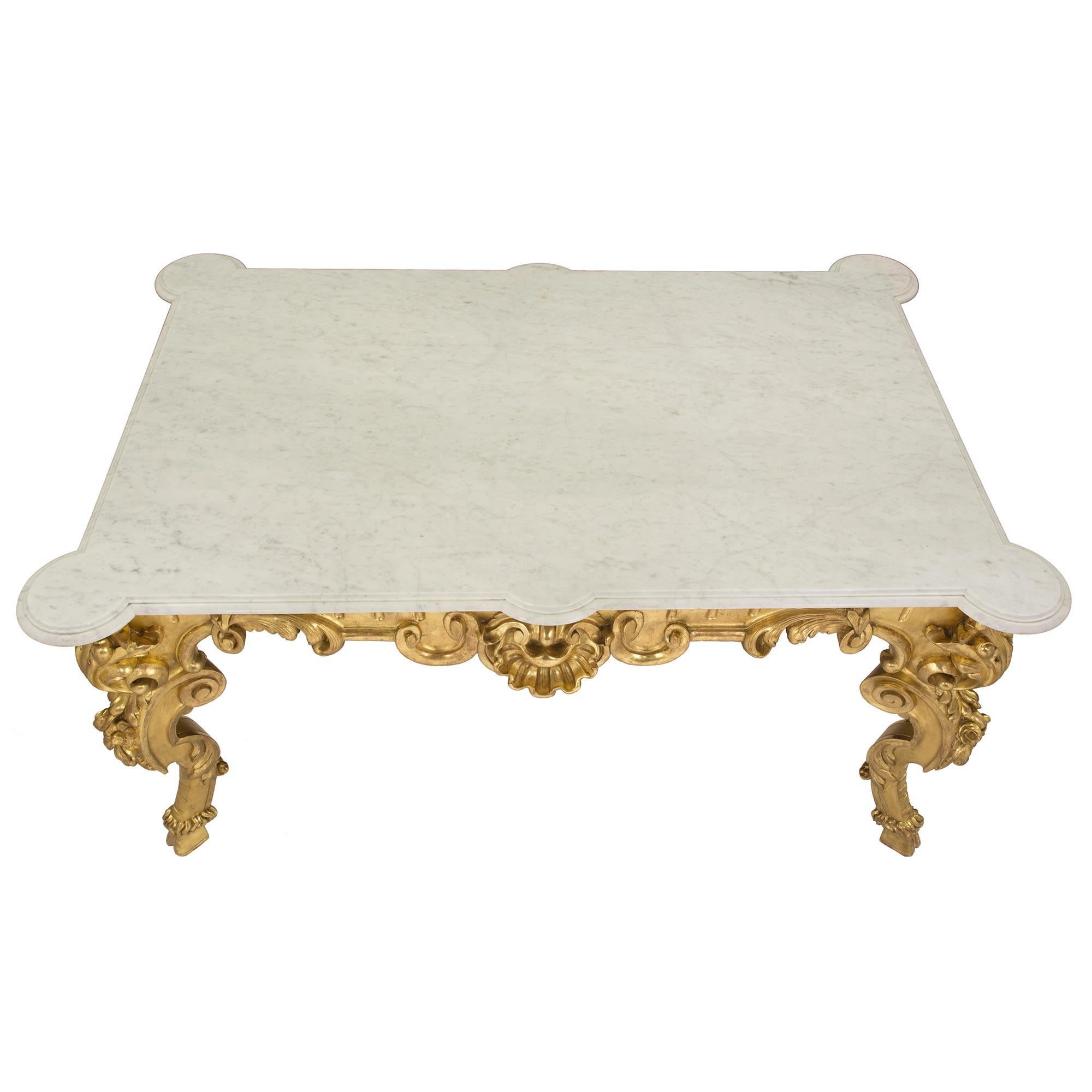 A most important and large scale Italian early 19th century Louis XV st. giltwood center table. The rectangular shaped table is raised by four 'S' scrolled legs with most impressive and richly carved acanthus leaves over bold flowers and ending with