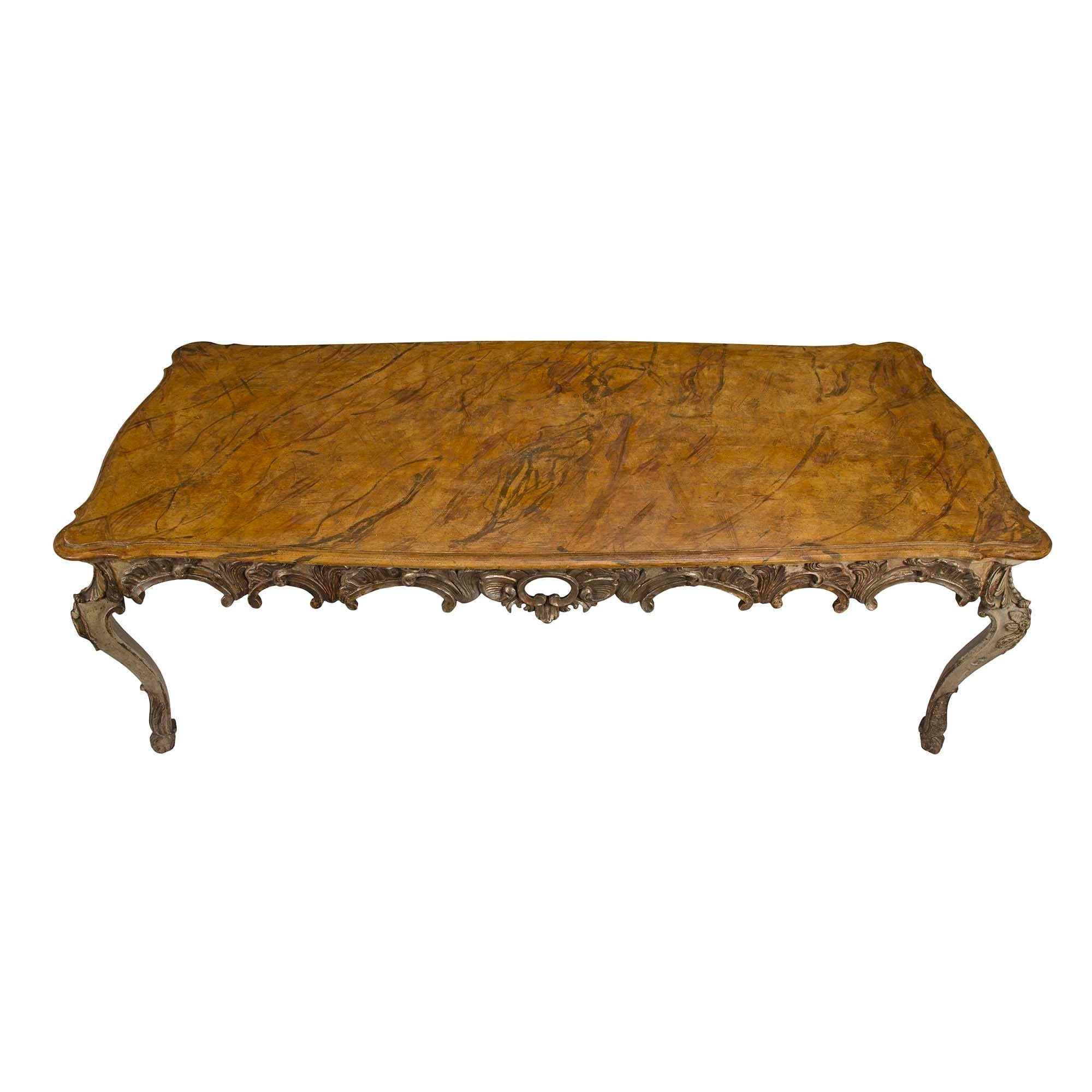 Une merveilleuse table de salle à manger italienne du début du 19ème siècle, de style Louis XV, patinée et mecca. La table repose sur des pieds cabriole décorés de feuilles d'acanthe et de grandes rosettes. L'impressionnante frise est centrée de