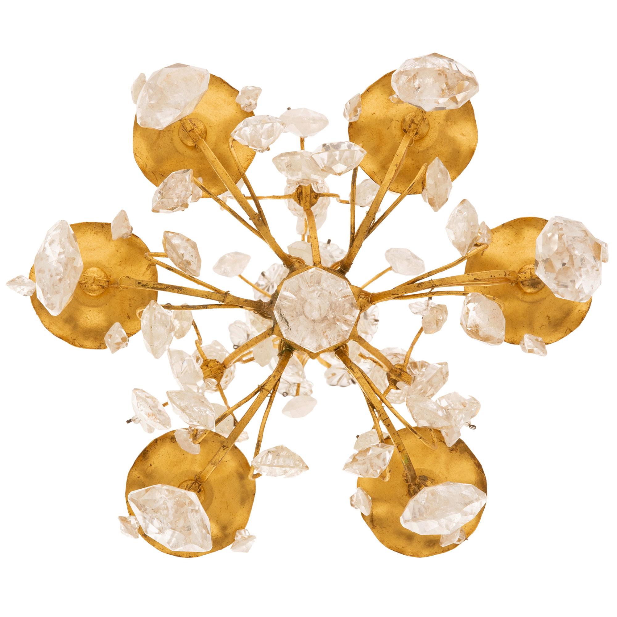 Ein eleganter und hochwertiger italienischer Kronleuchter aus dem frühen 19. Jahrhundert aus vergoldetem Metall und Bergkristall. Der sechsarmige Kronleuchter mit sechs Lichtern zeigt verschlungene C