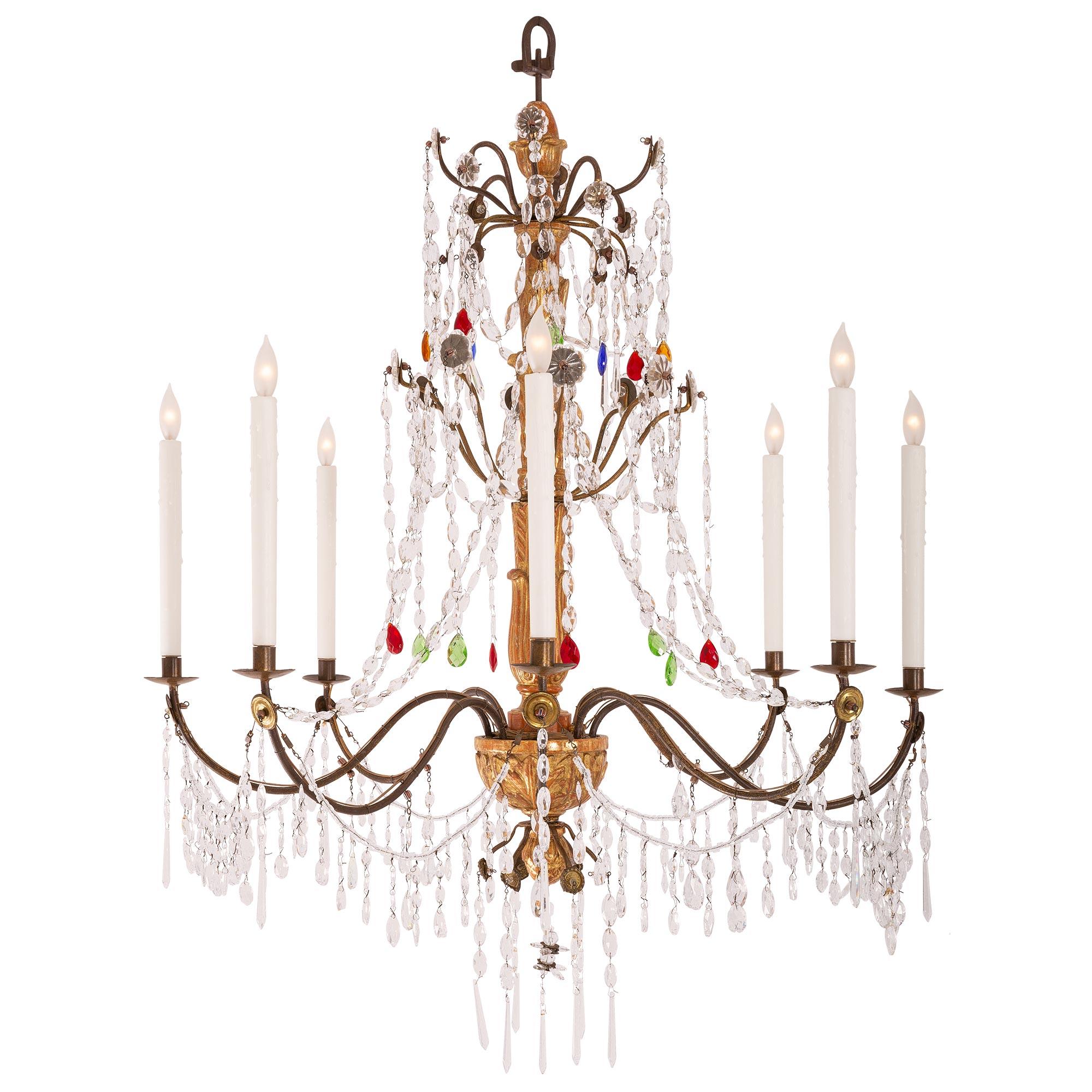 A beautiful Italian early 19th century Mecca, iron, crystal, and cut glass chandelier. The eight arm chandelier is centered by a lovely foliate finial centered by charming iron supports adorned with fine crystal pendants. At the center is a richly