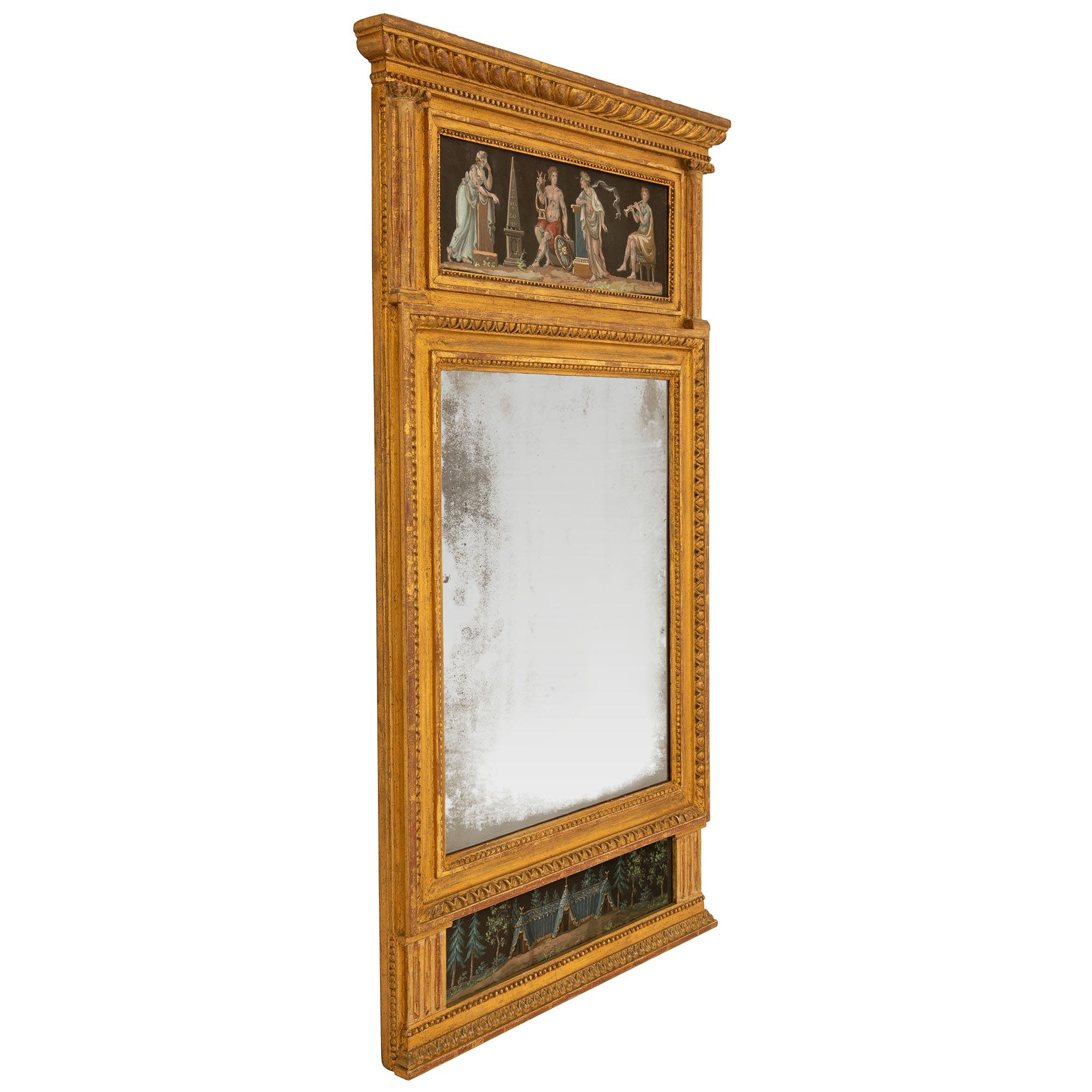 Exceptionnel miroir trumeau néoclassique italien du début du XIXe siècle en bois doré et gouache. Le miroir conserve sa plaque d'origine, entourée d'un fin bandeau perlé tacheté et d'une élégante bordure en forme d'œuf et de fléchette. À la base se