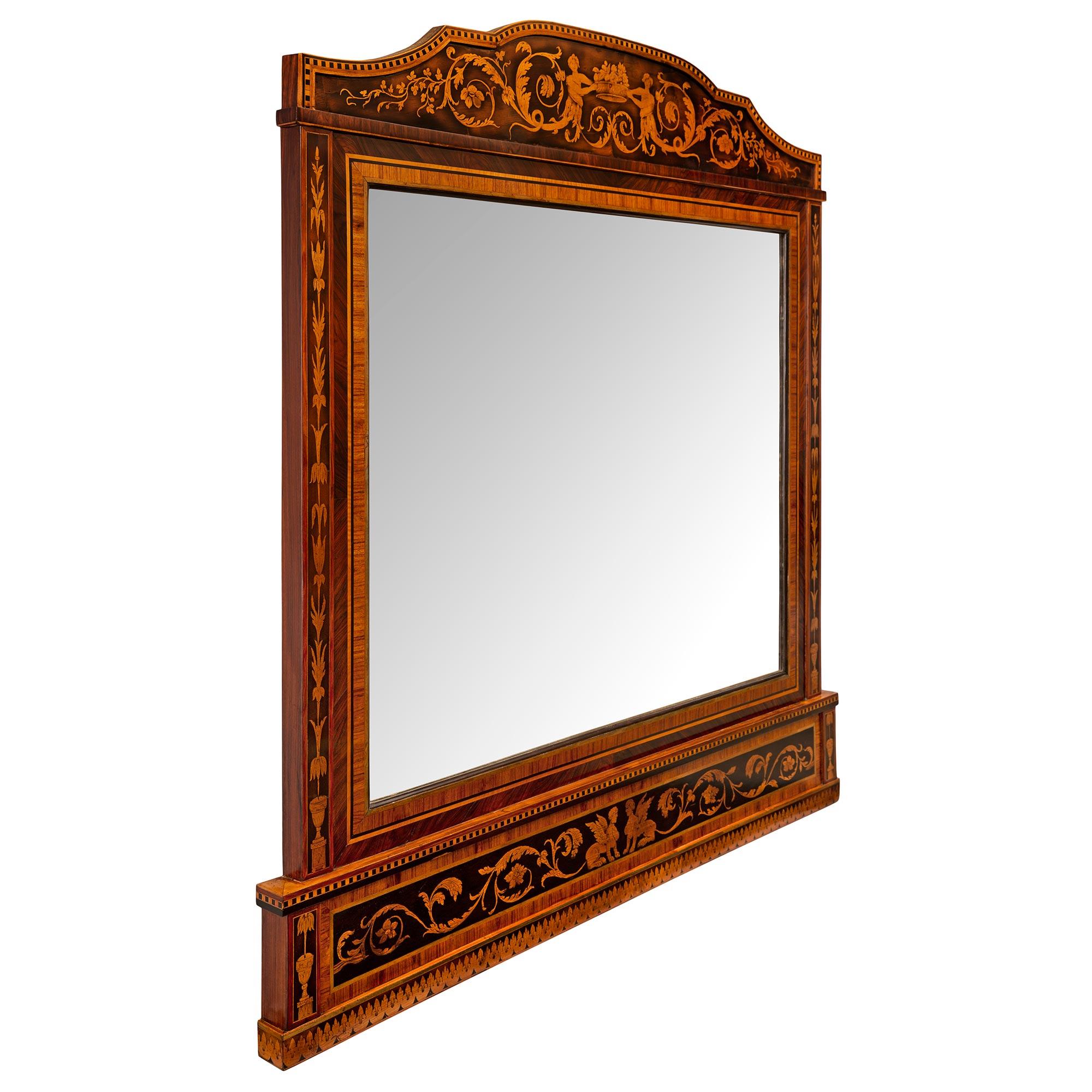 A beautiful Italian early 19th century Neo-Classical st. Kingwood, Tulipwood, and ebonized Fruitwood mirror in the manner of Giuseppe Maggiolini. The mirror retains its original mirror plate set within a fine mottled border. The base of the mirror