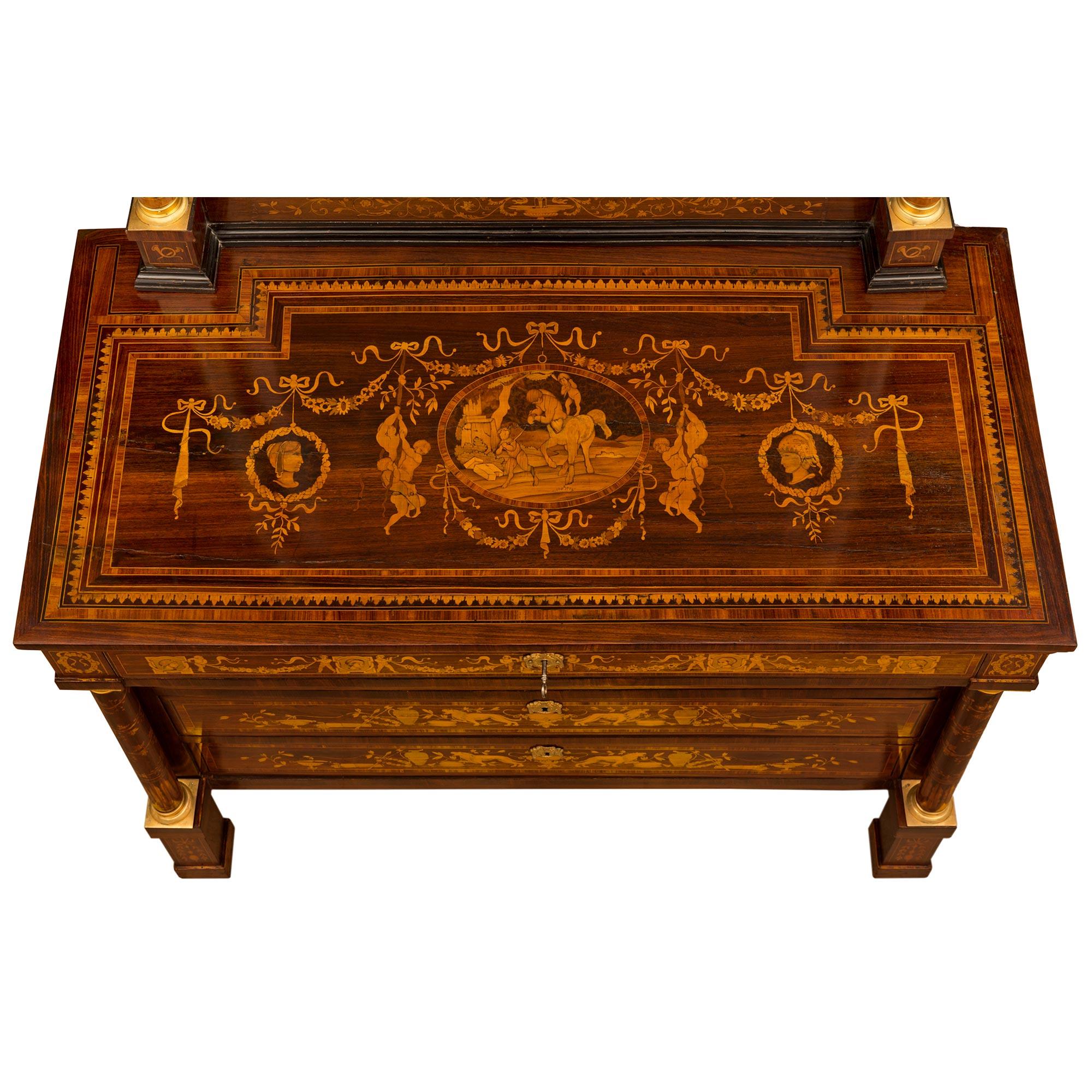 An exquisite and extremely decorative Italian early 19th century Neo-Classical st. ormolu, Fruitwood, and ebonized Fruitwood inlaid chest and original matching mirror. The four-drawer chest in the manner of Giuseppe Maggiolini is raised by elegant