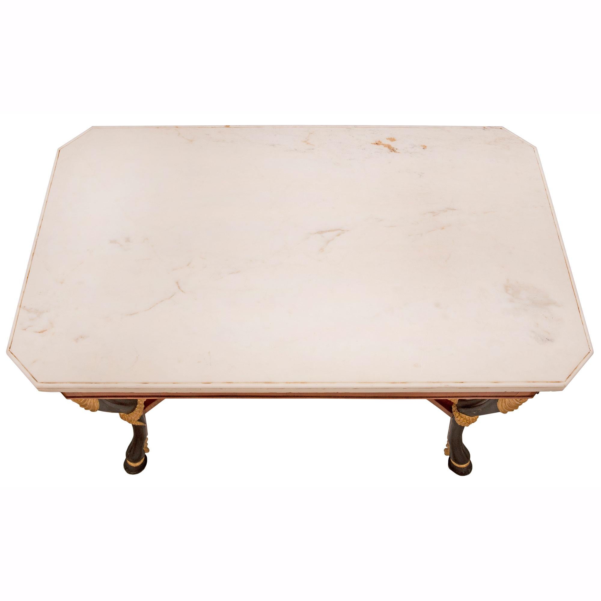 An impressive Italian early 19th century Neo-Classical st. walnut, polychrome, giltwood and white Carrara marble center table, from Naples. The rectangular table is raised by striking polychrome legs with most decorative hoof feet, and fine