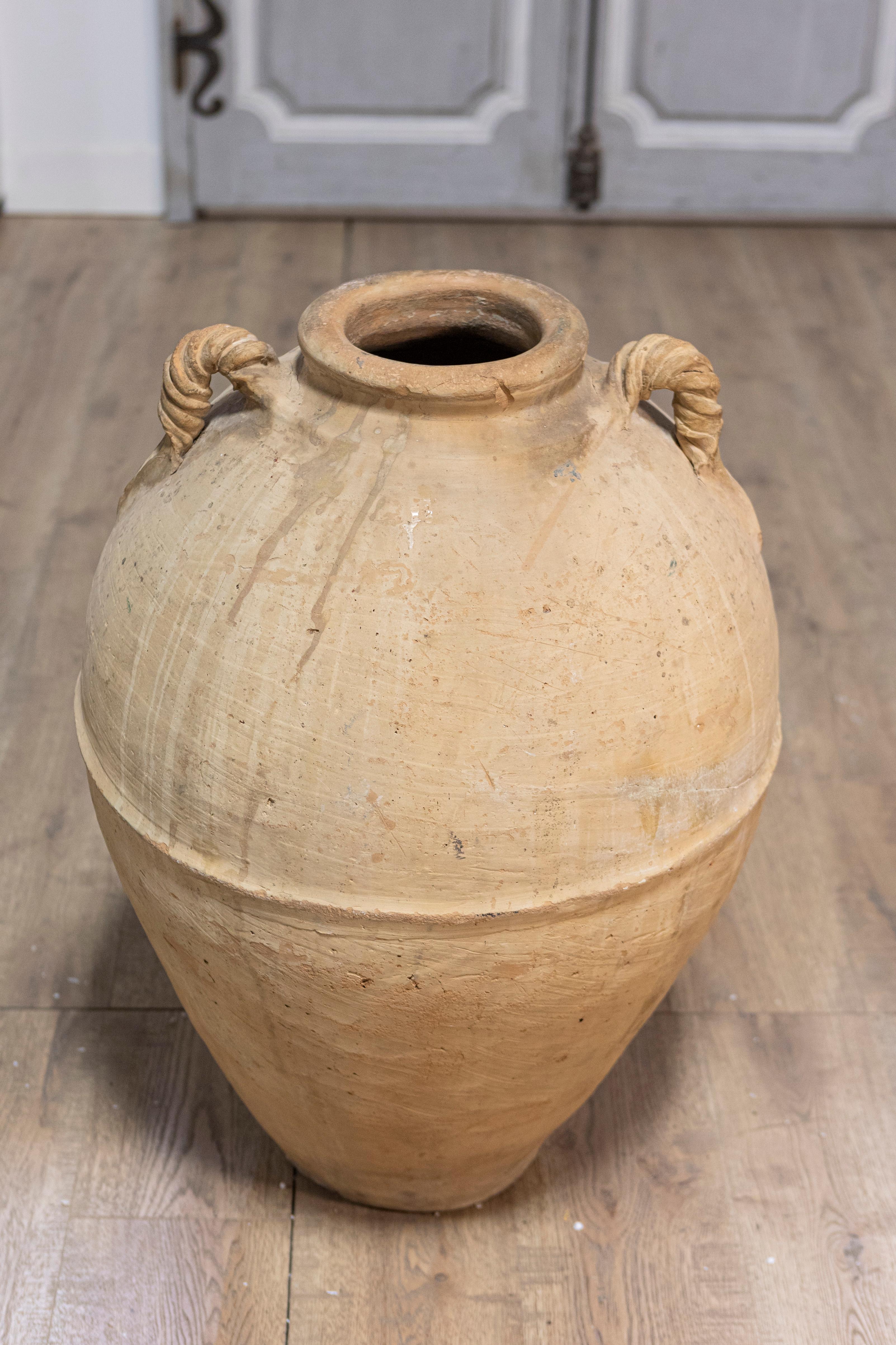Jarra de aceite de oliva de terracota de principios del siglo XIX, procedente de Nápoles (Italia), con asas retorcidas y carácter rústico. Este tarro de aceite de oliva de terracota de principios del siglo XIX, procedente de Nápoles, desprende
