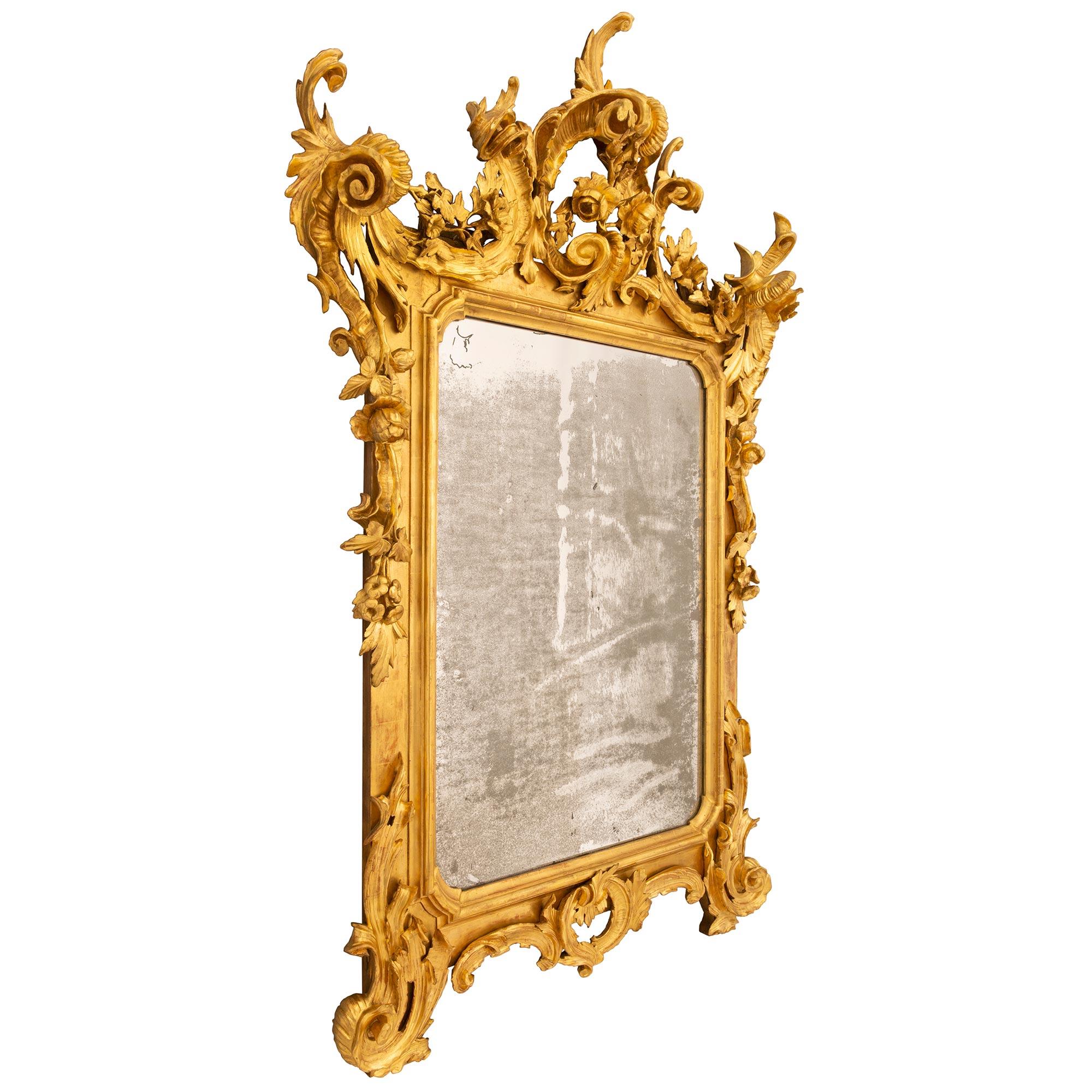 A spectacular and most impressive Italian early 19th century Venetian st. Giltwood mirror. This richly carved mirror is raised by two 'S' scrolled foliate supports flanking the pierced central reserve which is designed with similar scrolled leaves.