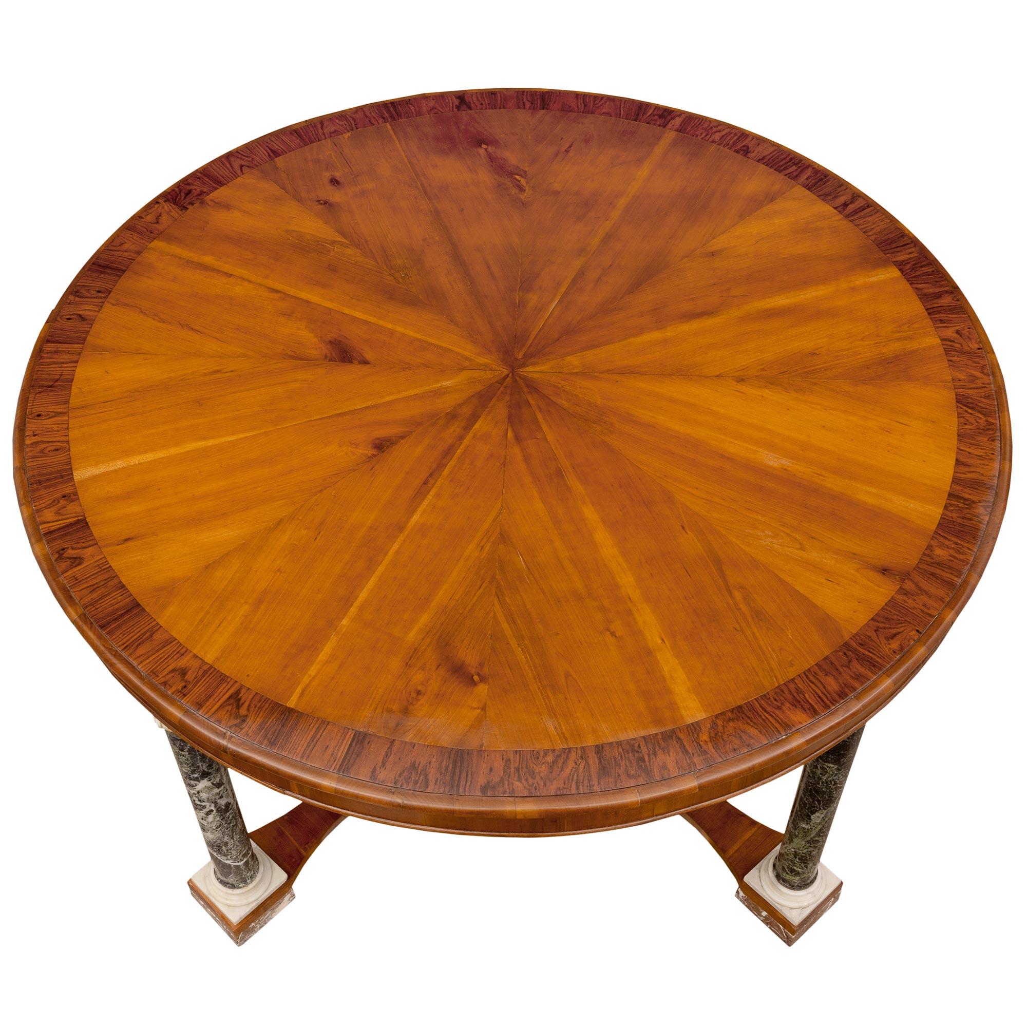 A most impressive and large scale Italian early 19th century neo-classical st. walnut, rosewood white carrara, Vert Maurin and Rose Vif des Pyrénées marble center table. The striking circular table is raised by fine Rose Vif des Pyrénées marble