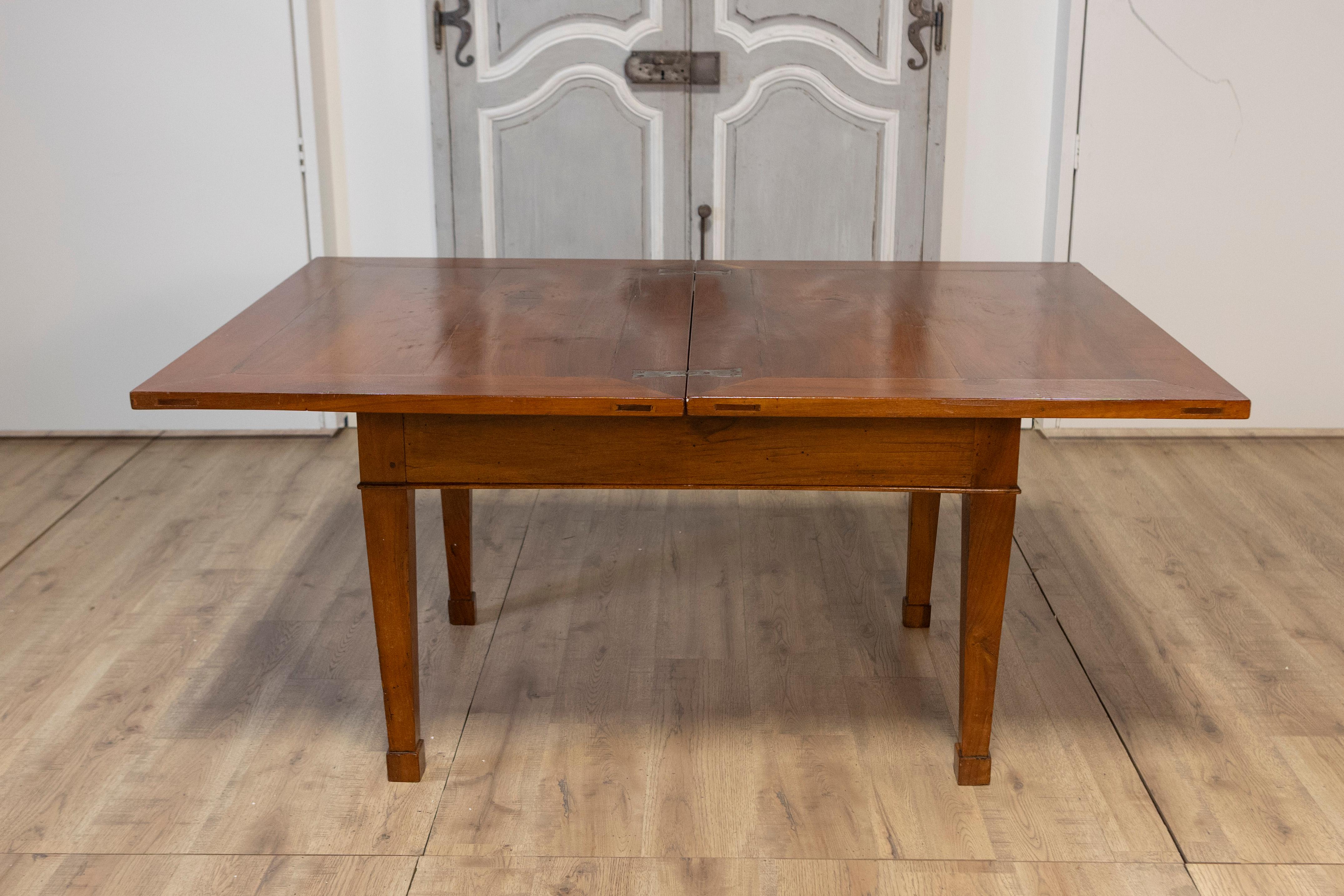 This exquisite Italian walnut folding table from the early 19th century embodies classic elegance with practical functionality. Featuring a versatile design, the table measures 65.5