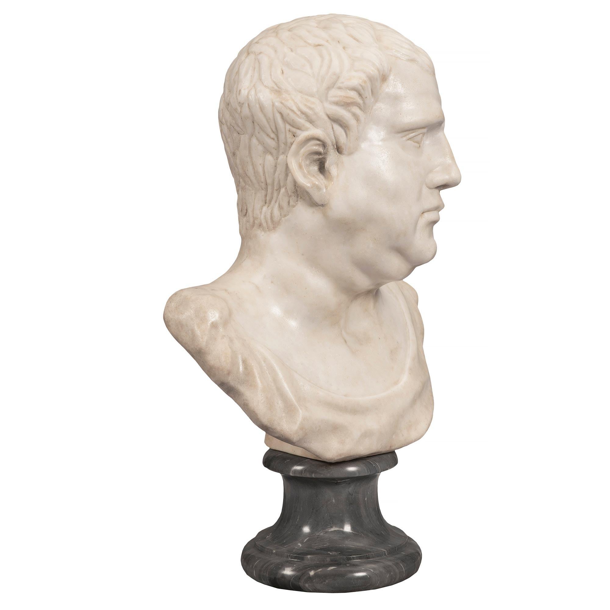 A handsome and high quality Italian early 19th century white Carrara marble bust of a Roman Emperor. The bust is raised by a circular Bleu Turquin marble base with a decorative mottled border. The masterfully sculpted bust of the man above displays