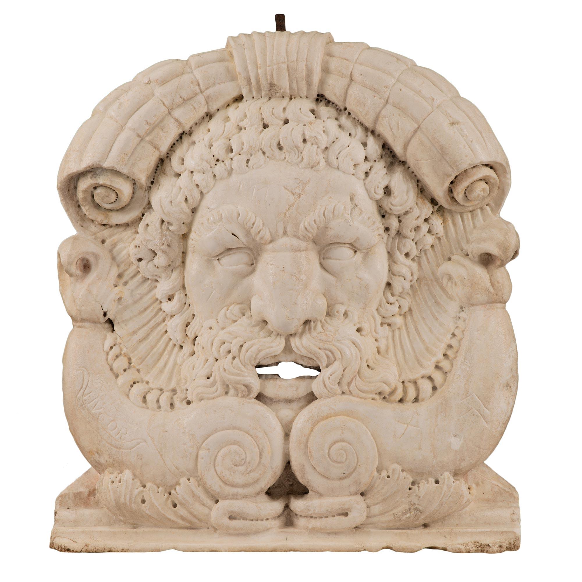 A stunning Italian early 19th century white carrara marble fountain head signed HVGOR. This most impressive and masterfully sculpted fountain head displays intricate attention to detail throughout. At the center is an exceptional and handsome