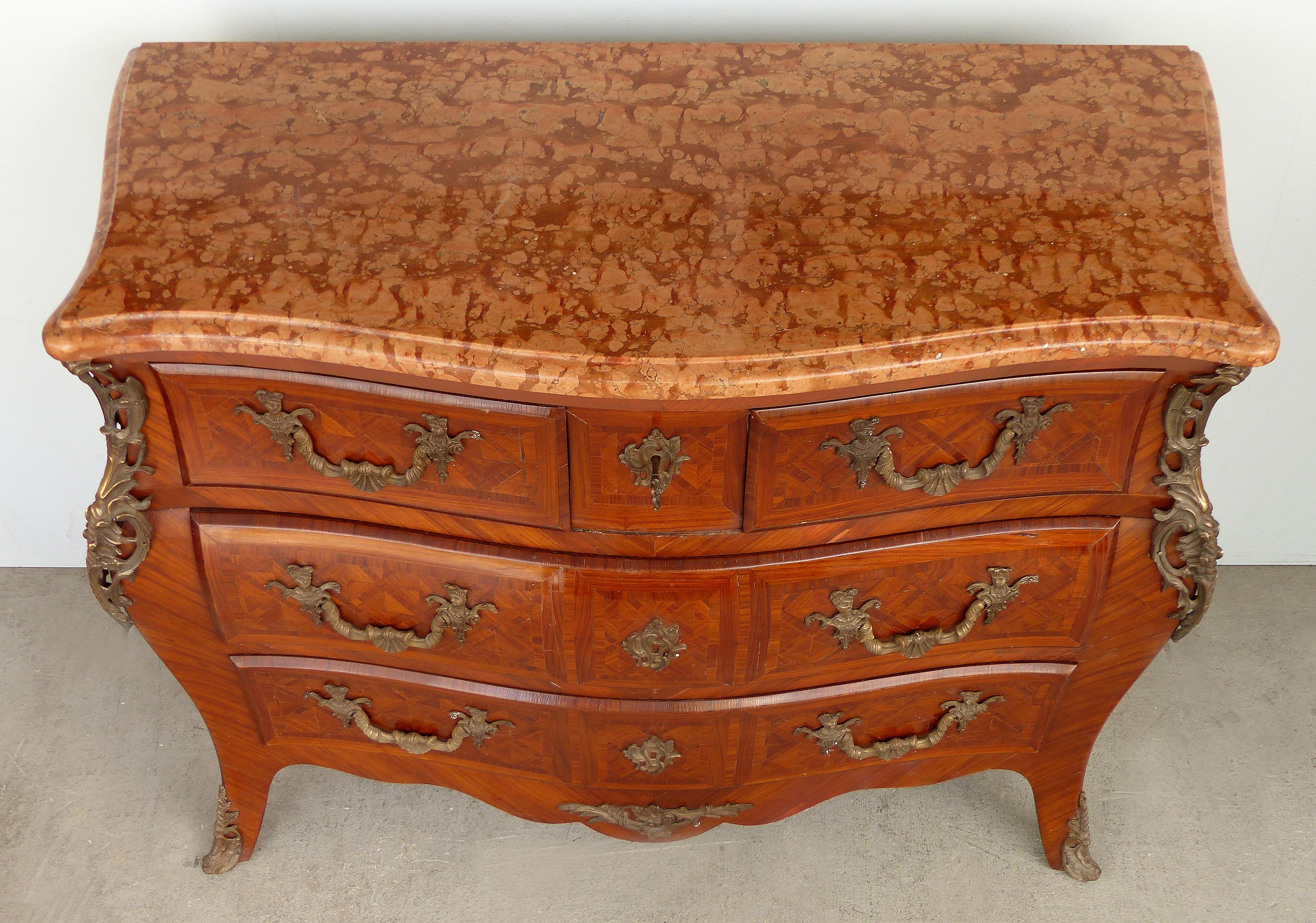 Italian Early 20th Century Bombe Commode with Bronze Mounts and Marble Top

Offered for sale is an early 20th century Italian bombe commode with wonderful parquetry and ornate bronze hardware. A fresh find from a Miami Beach estate, this beautiful
