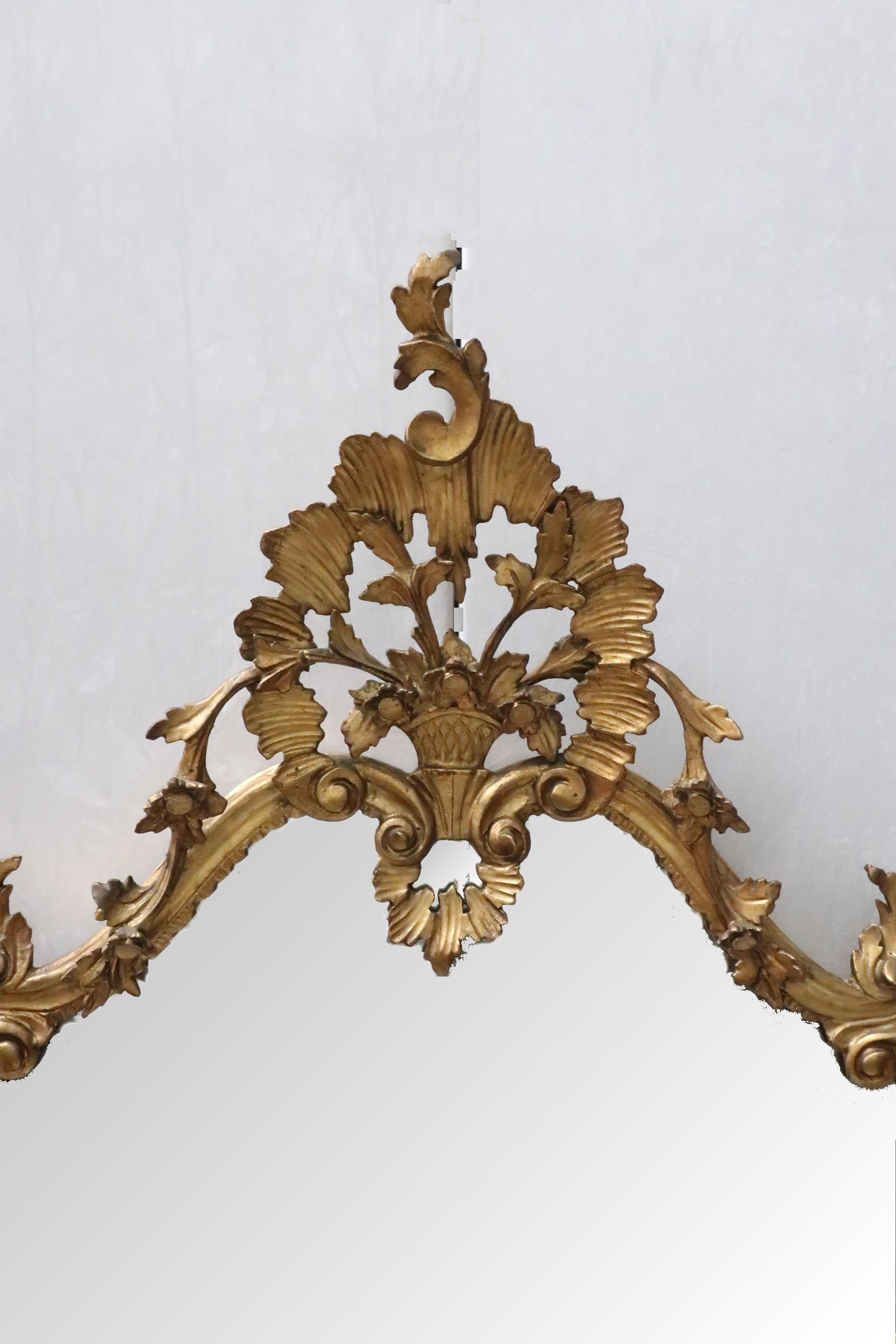 An extremely good quality Italian carved wooden gilt wall mirror with scrolling floral leaf design throughout still retaining its original gilding which is in excellent condition. The mirror also retains its original mirror plate which is in very