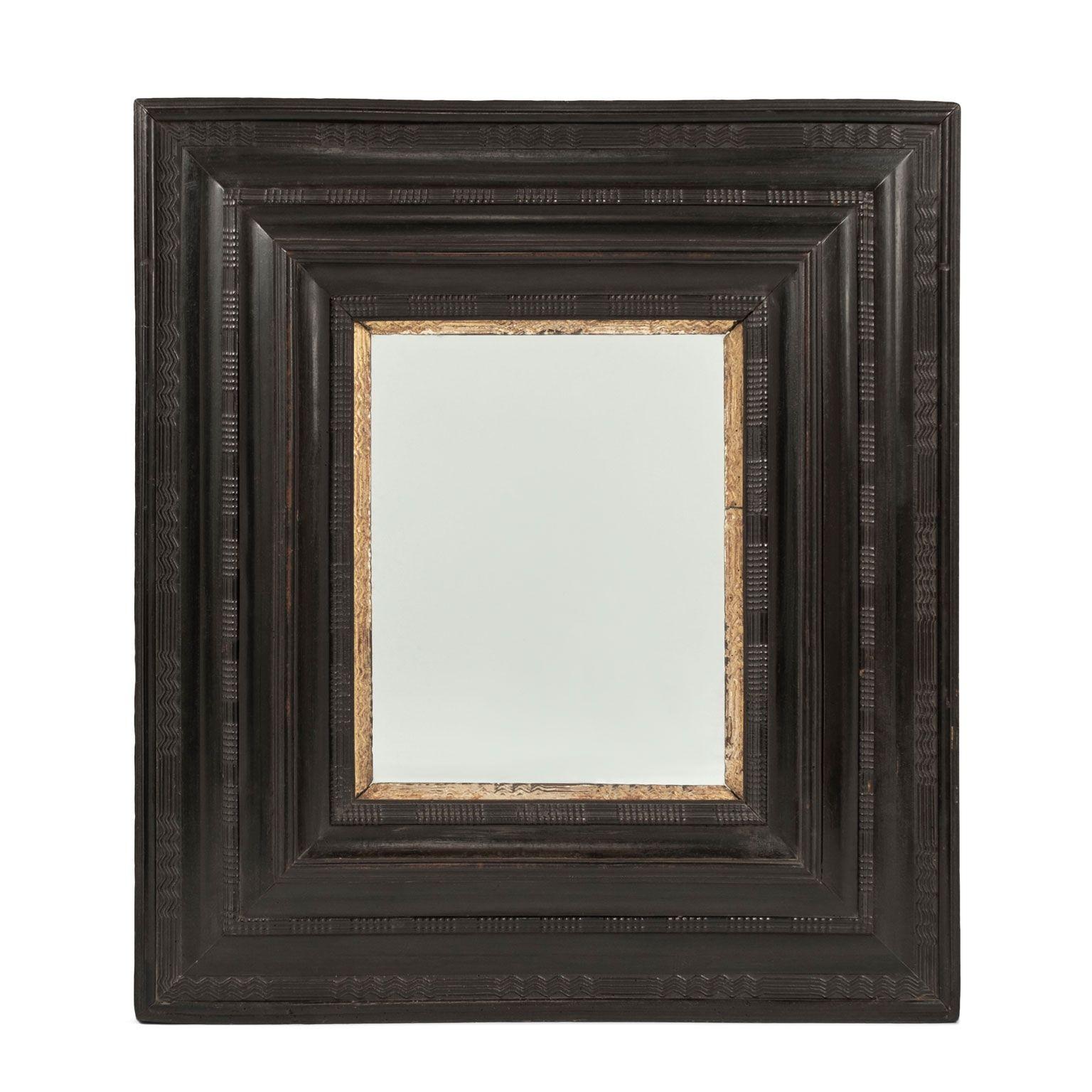 Miroir italien en bois ébonisé et doré daté du milieu du XVIIIe siècle. Cadre ébonisé sculpté à la main avec garniture intérieure en bois doré sculpté. Miroir en verre ancien, mais pas d'origine.
