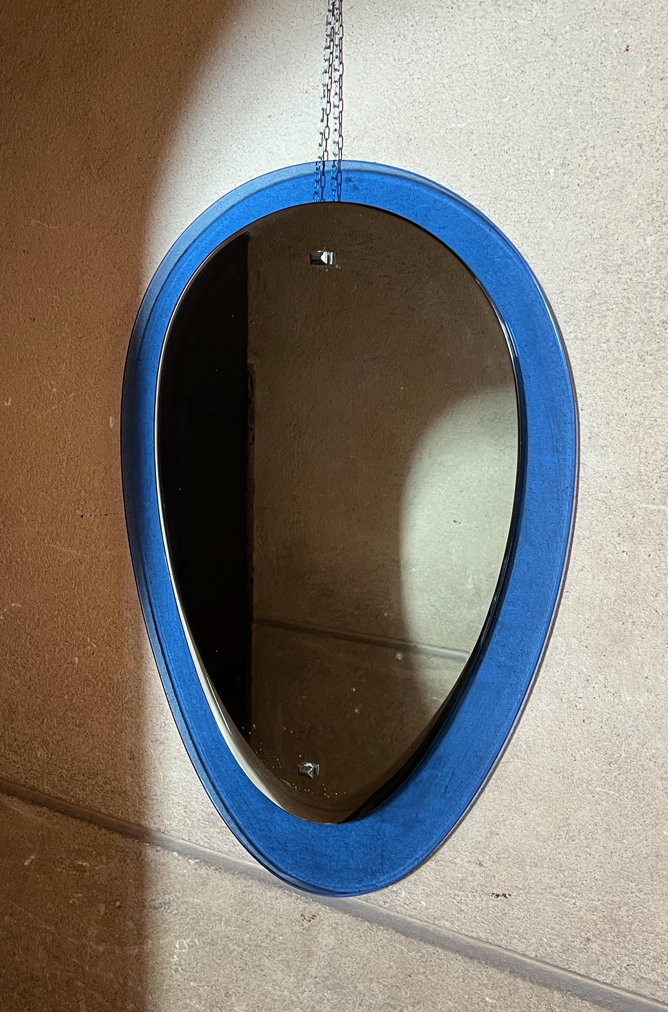 Ein atemberaubendes italienisches Meisterwerk: Dieser elektrisch blaue Spiegel hat eine wunderschöne tropfenförmige Silhouette. Der anmutig erhabene ovale Mittelteil aus verspiegeltem Glas erzeugt einen schwebenden Effekt, der das Auge fesselt.