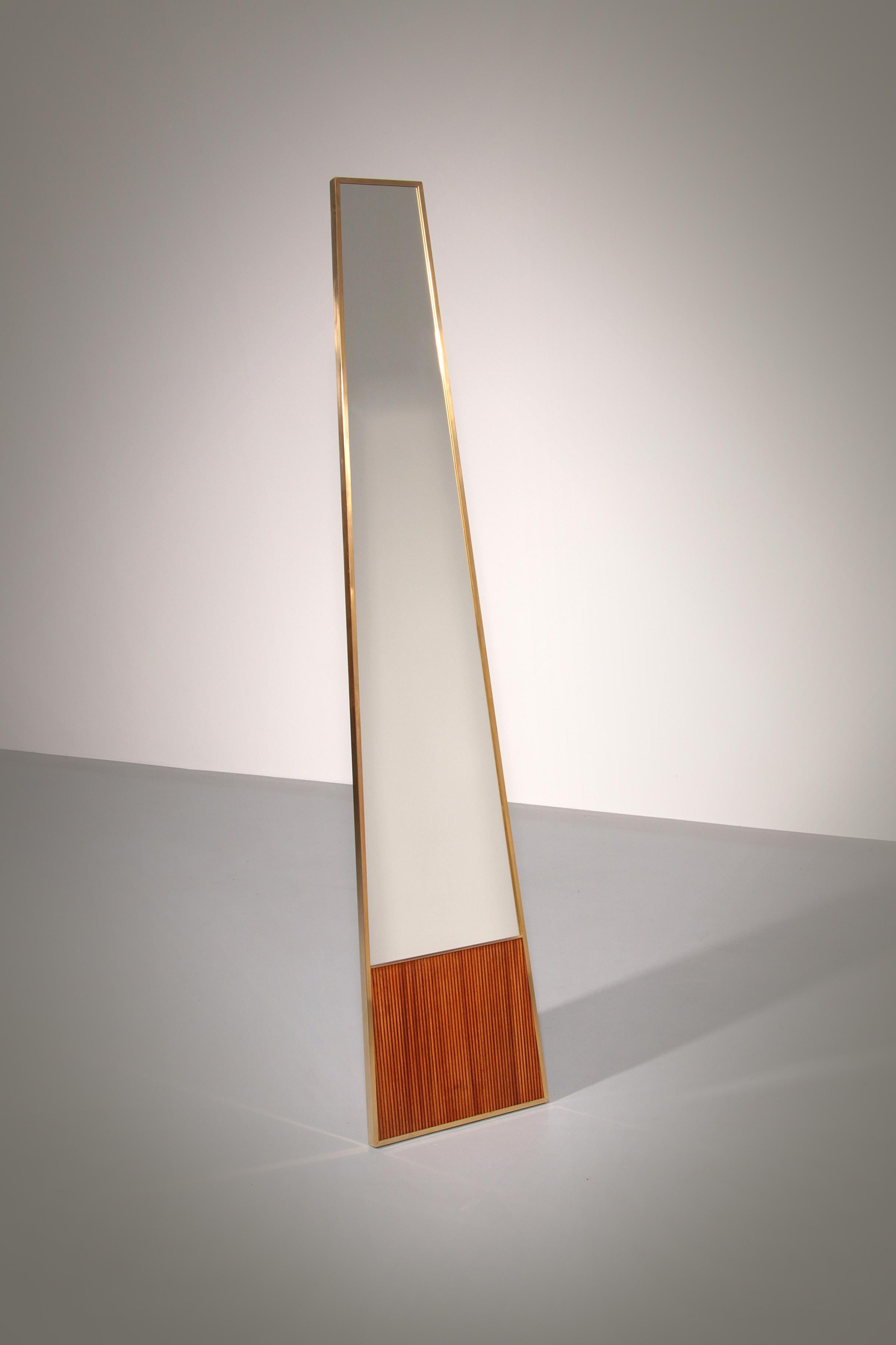 

This stylish standing mirror from Italy, made in the 70s, combines timeless elegance with high-quality materials. The mirror stands completely on its own and features a subtle oak detail at the bottom and a refined brass edge. This unique design