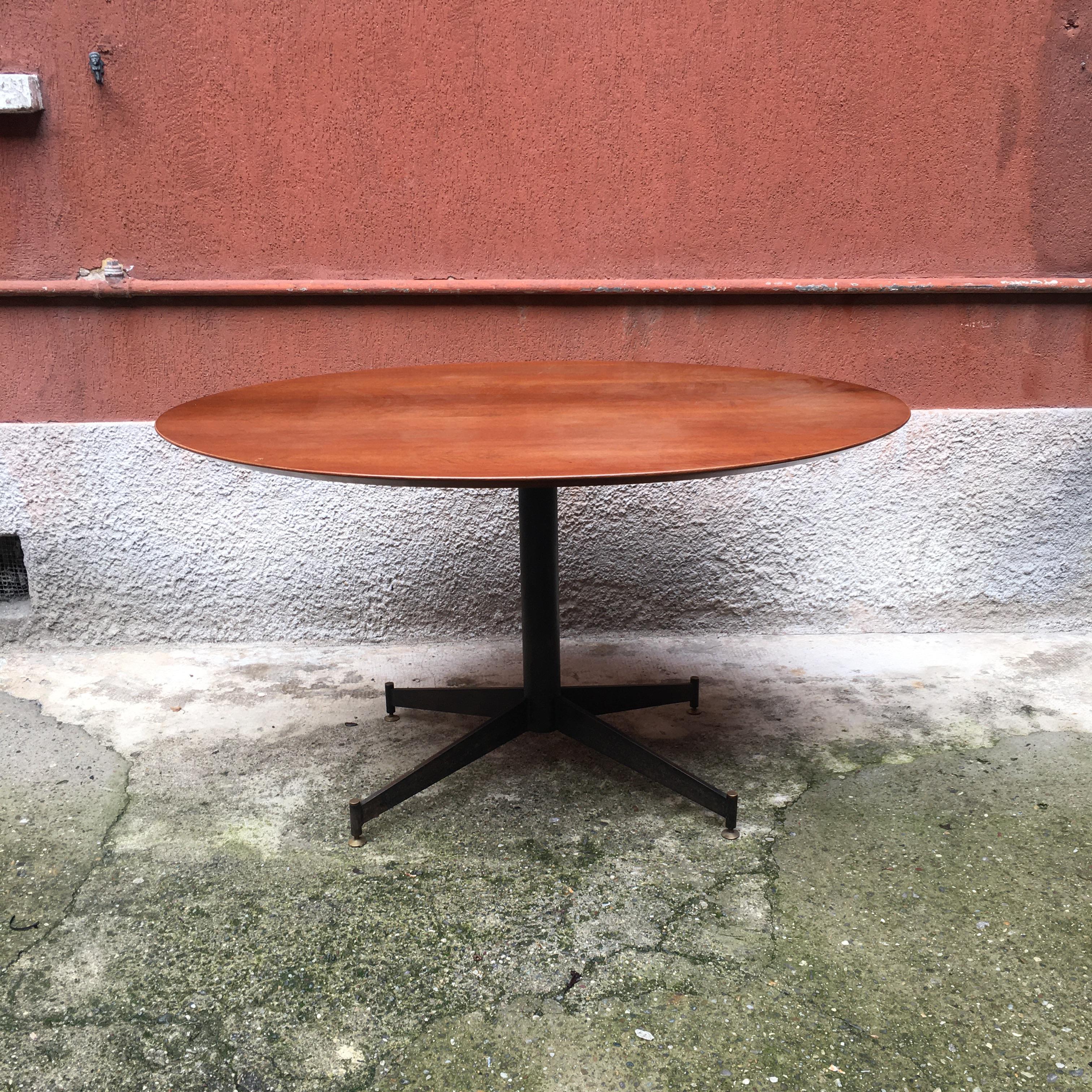 Italian elliptical teak and metal dining table, 1950s
Dining table with elliptical teak top and black metal frame with brass details and tips.