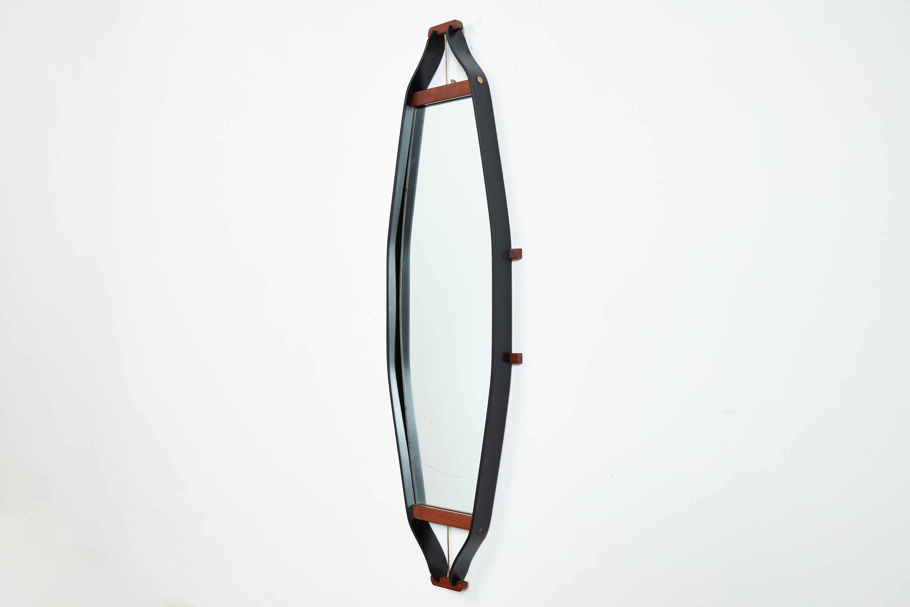 1950's Italian mirror in elongated iron frame and teak wood detailing with brass hardware.  Unique in shape and excellent craftsmanship. 
Original tag from Bologna, Italy. 