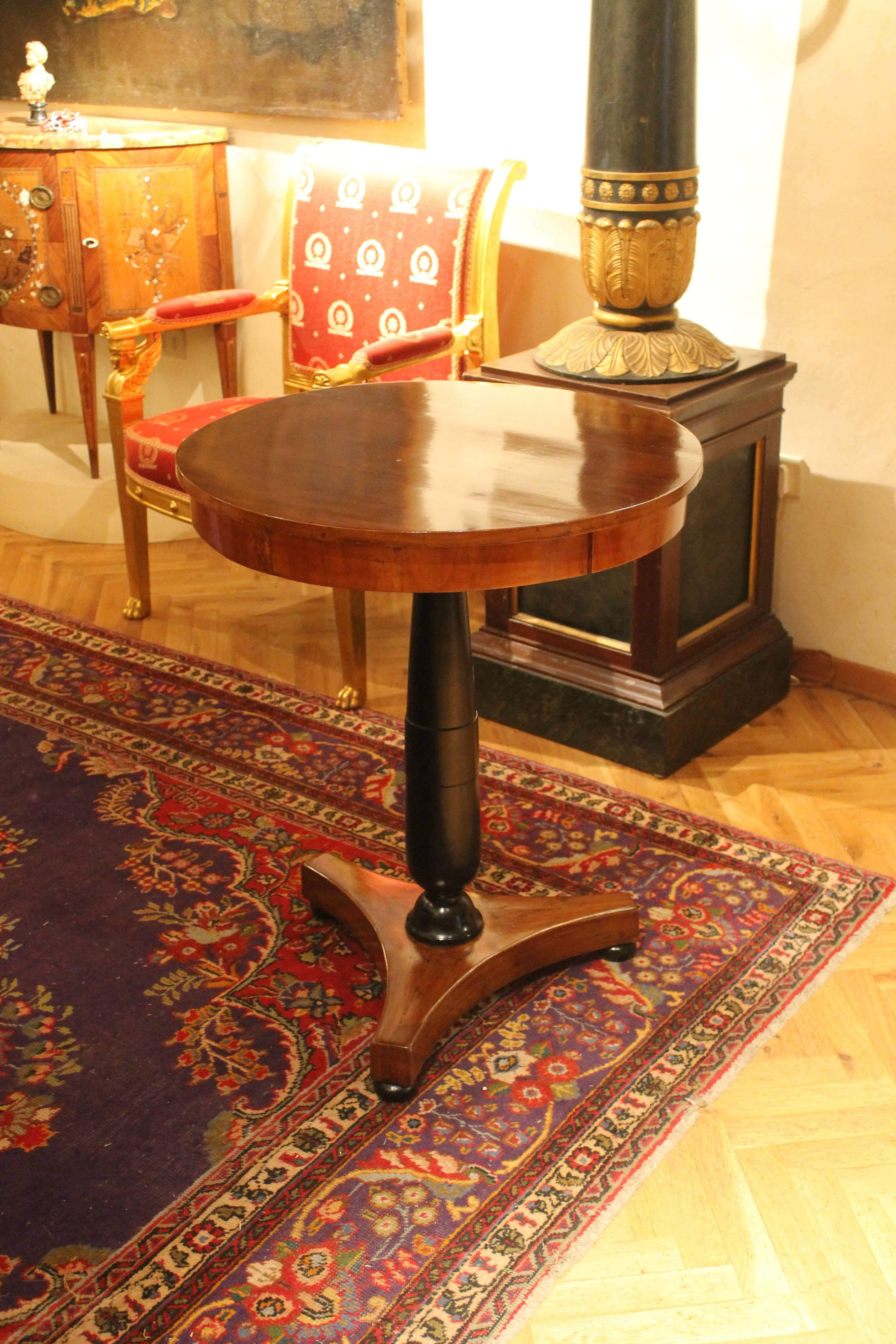 This beautiful antique early 19th century Italian Empire circular centre table in blonde flamed walnut wood and black ebonized wood comes from a villa in Tuscan countryside. This is a very good quality side table with circular top sitting above a