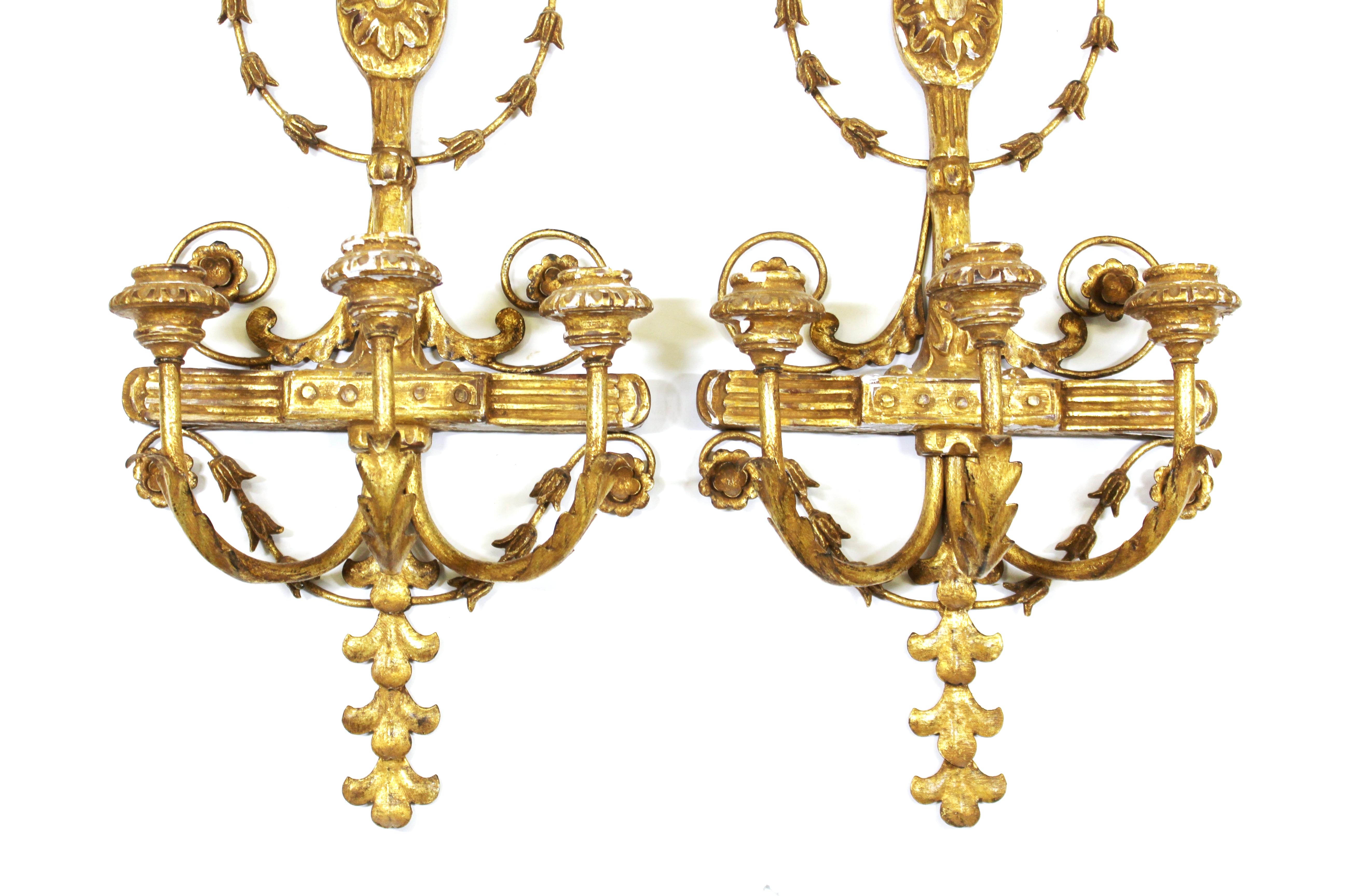 Italian pair of Empire Revival style wall candle sconces in carved giltwood. 'Made in Italy' marks on the backs. In great vintage condition with age-appropriate wear and distressed look.