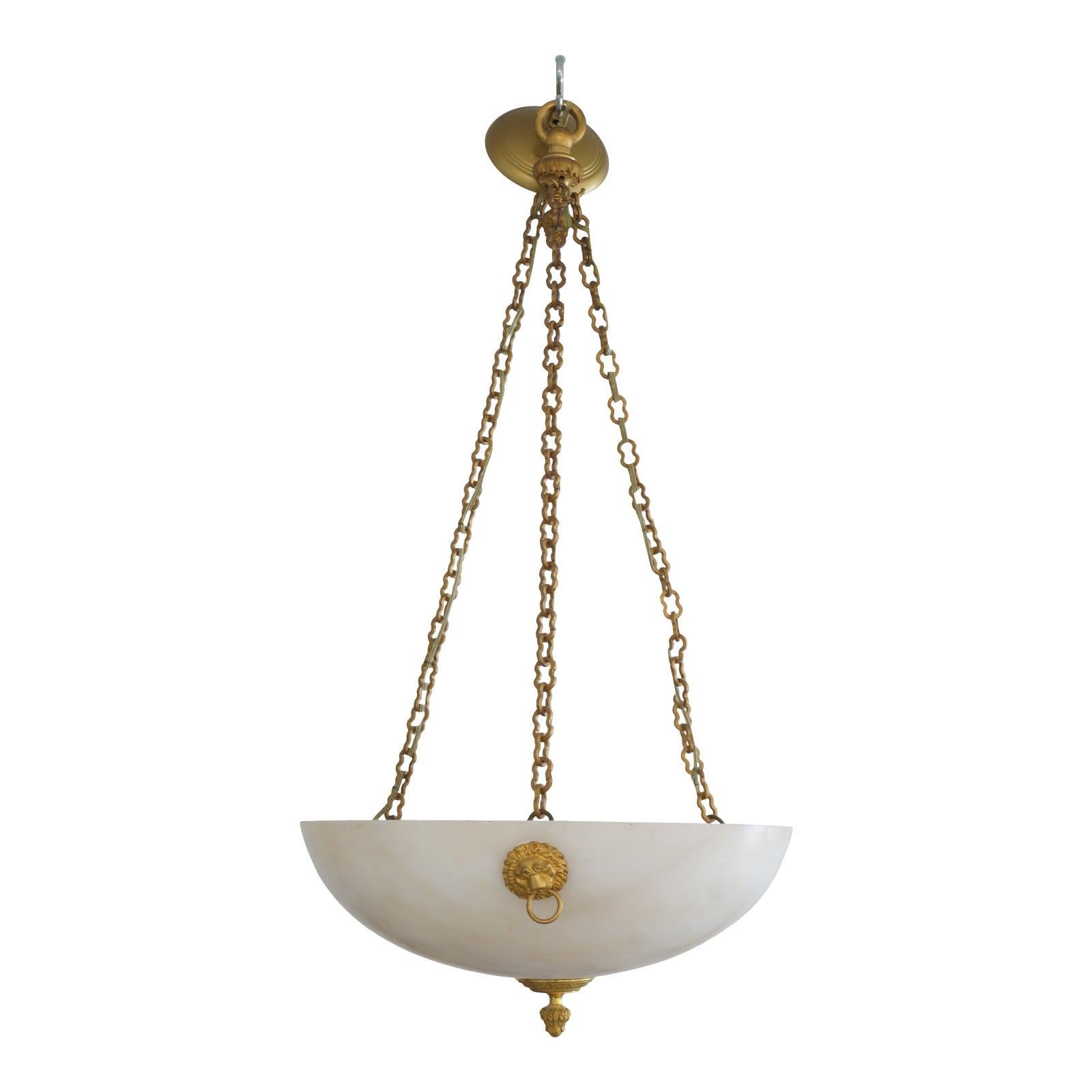 This stylish and chic Italian empire style chandelier dates to the 1920s-1930s and is fabricated in bronze dore and alabaster. 

Note: Requires three Edison based light bulbs.

Note: There is an inclusion on the outside of the alabaster rim (see