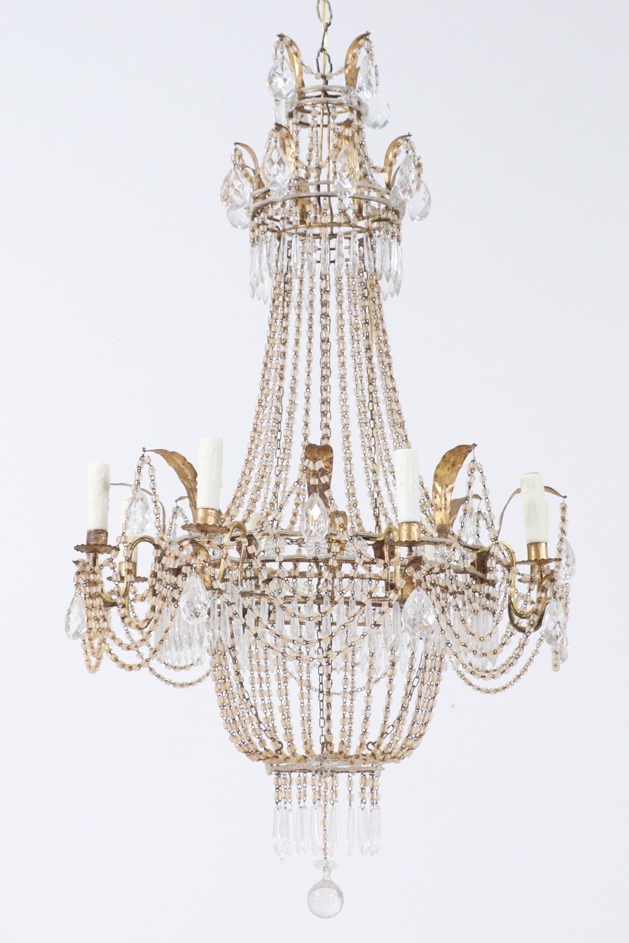 Gorgeous, 1940s Italian crystal beaded chandelier in the Empire style.

The chandelier consists of a leafy gilt iron frame decorated with macaroni glass bead drapes. The beads have acquired a pleasing rusty patina over the decades adding to its