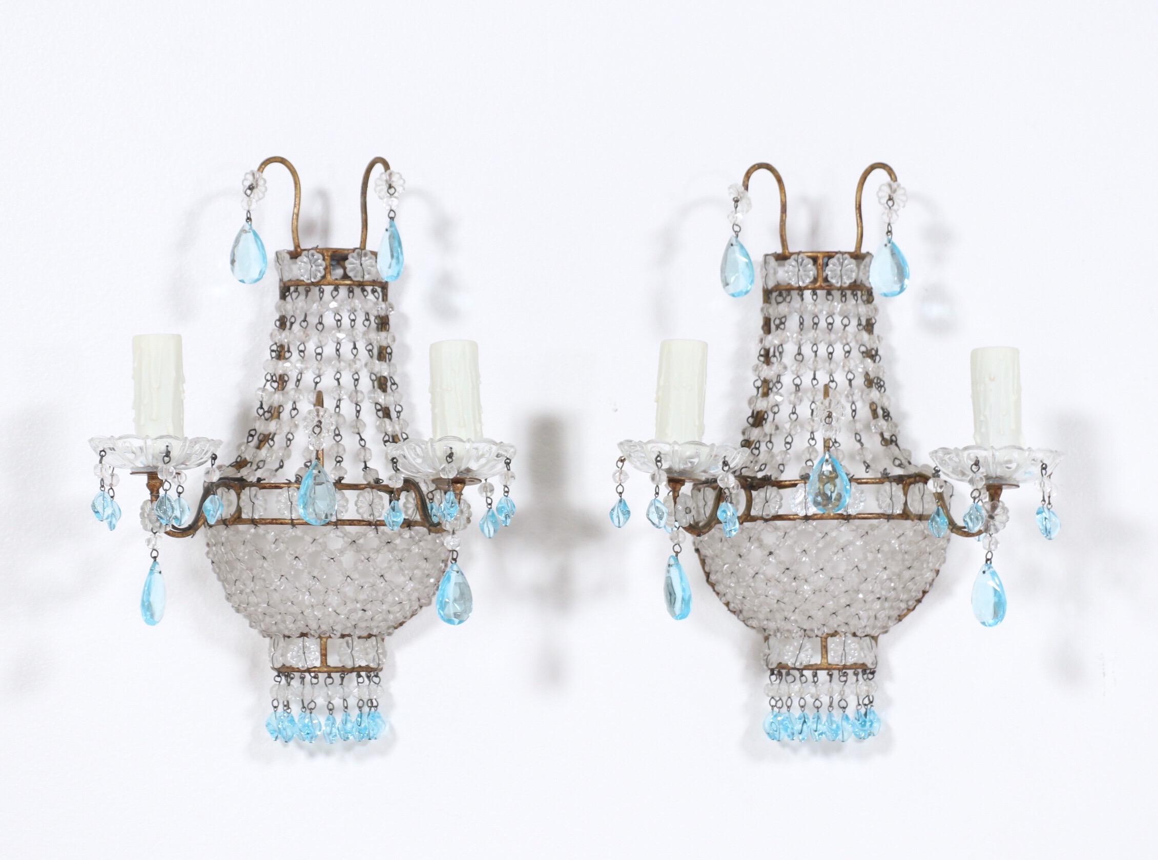 Gorgeous, 1940s Italian gilt-iron and crystal beaded sconces with light blue drops in the Empire style.

These petite-scale beauties feature gilt iron frames with delicately weaved crystal beaded bases, and crystal boebeches. The sconces are