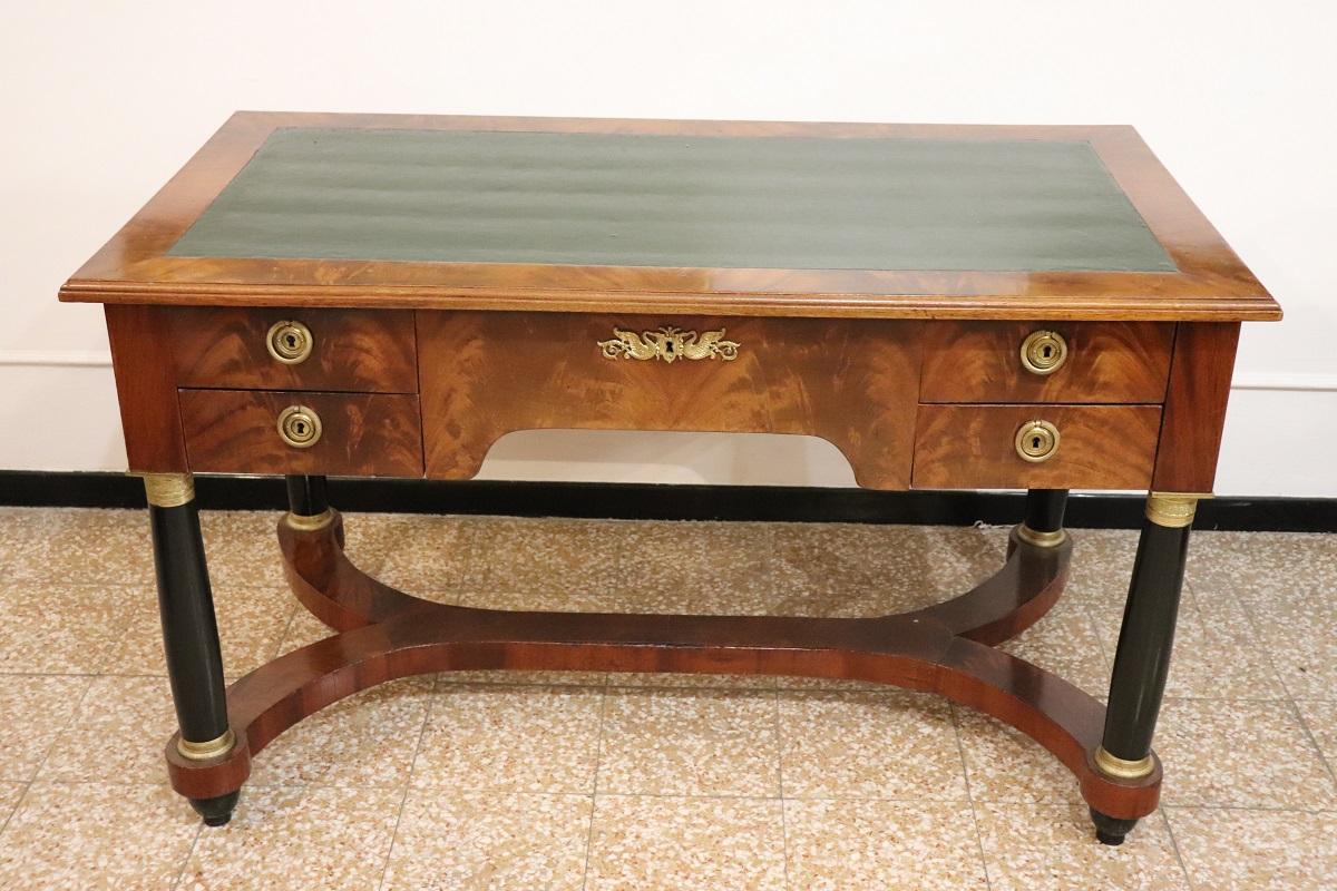 Introducing this elegant Italian desk dating back to the 20th century. An extremely refined desk, inspired by the Empire style.

Featuring a linear design with black ebonized column legs that highlight the top. On the front you will have five