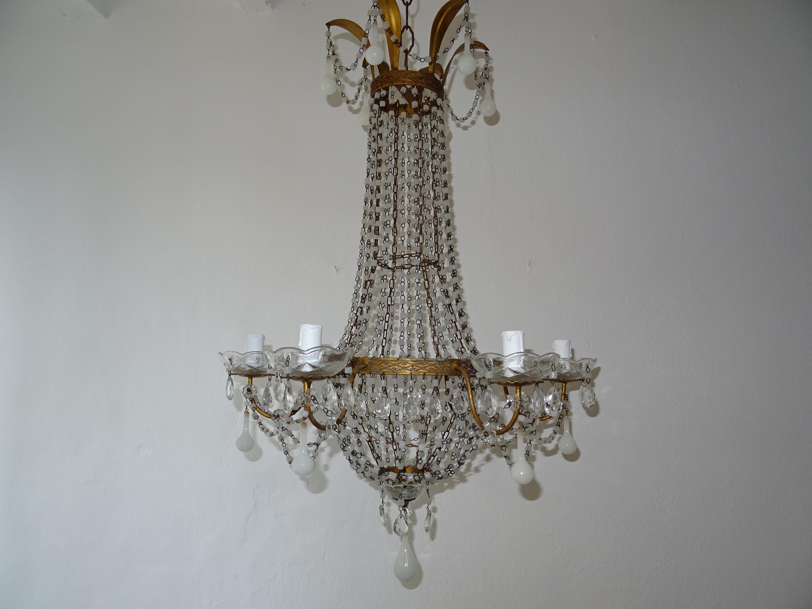 Housing 6 lights, sitting in crystal bobéches, dripping with white opaline beads and vintage crystal prisms.  Will be rewired with certified UL US sockets for the USA and appropriate sockets for all other countries and ready to hang. Metal body with
