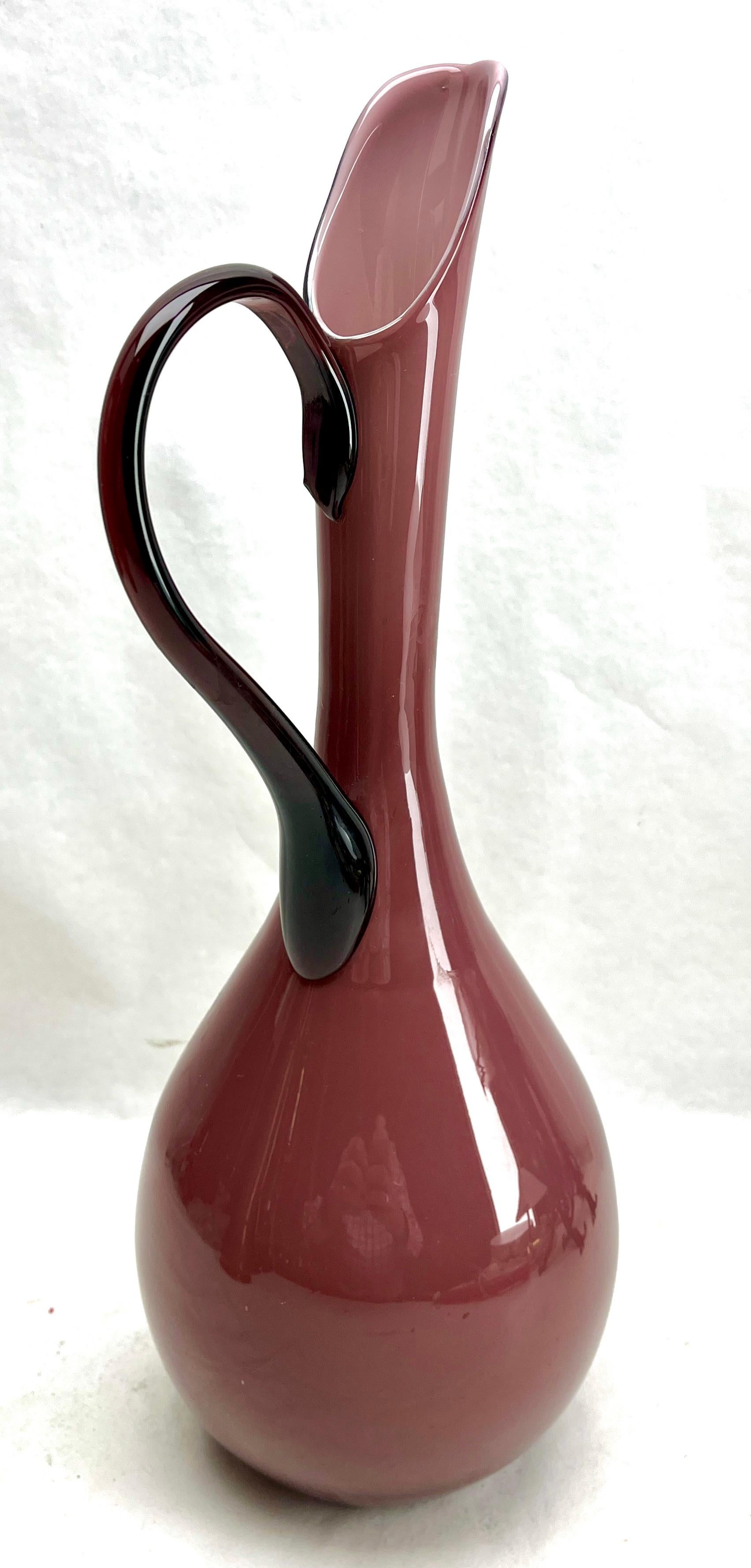Vintage Italian Empoli  Murano cased art glass pitcher
Weight: 1 Kg
Hand blown cased glass pitcher with handle made in the mid-1955s  Irresistibly chic  glass encased in creme glass set off by a  classical Murano glass handle. 
Excellent