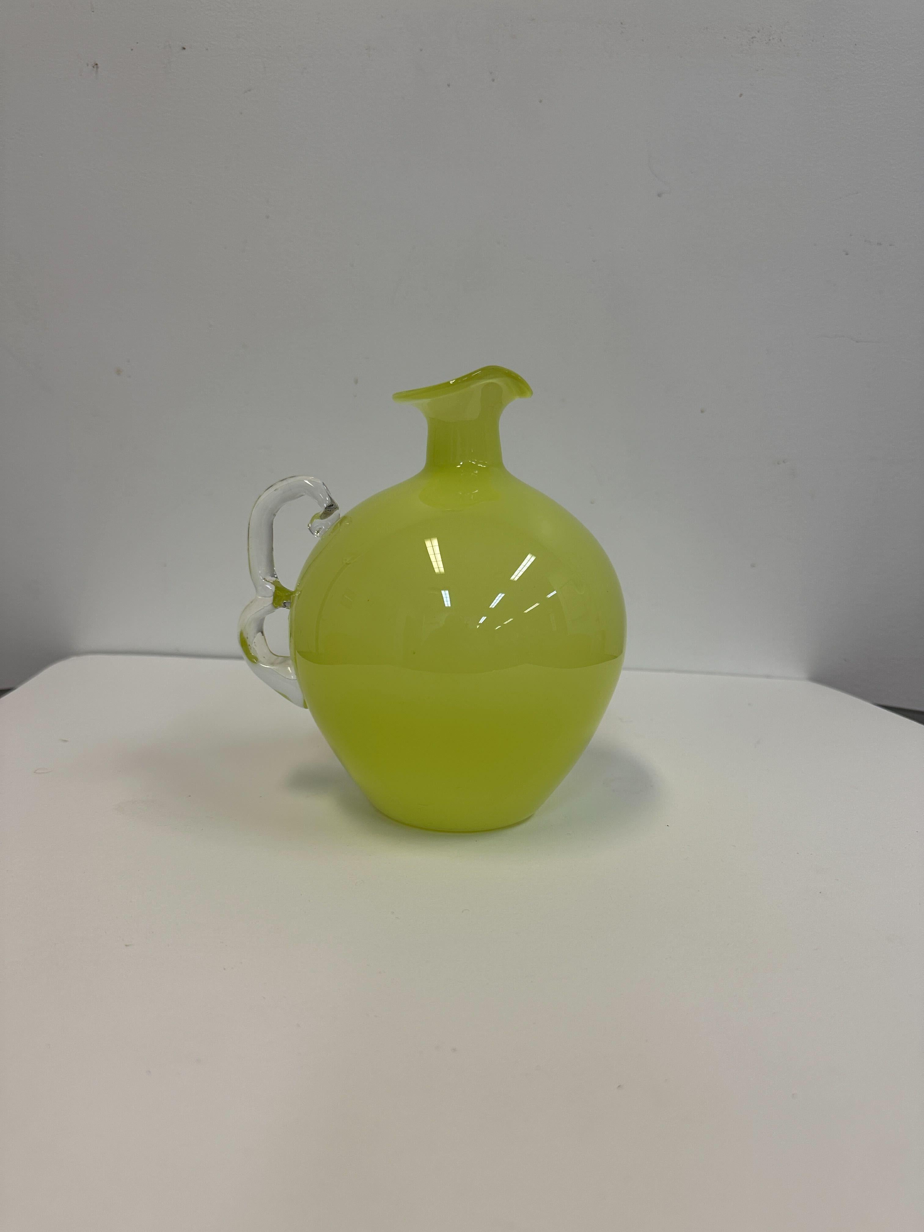 Handblown cased glass pitcher with twisted handle made in the mid-1950s by the Italian firm Empoli. Irresistibly chic olive green glass encased in clear glass set off by a clear classical twisted Murano glass handle. A fantastic mingling of