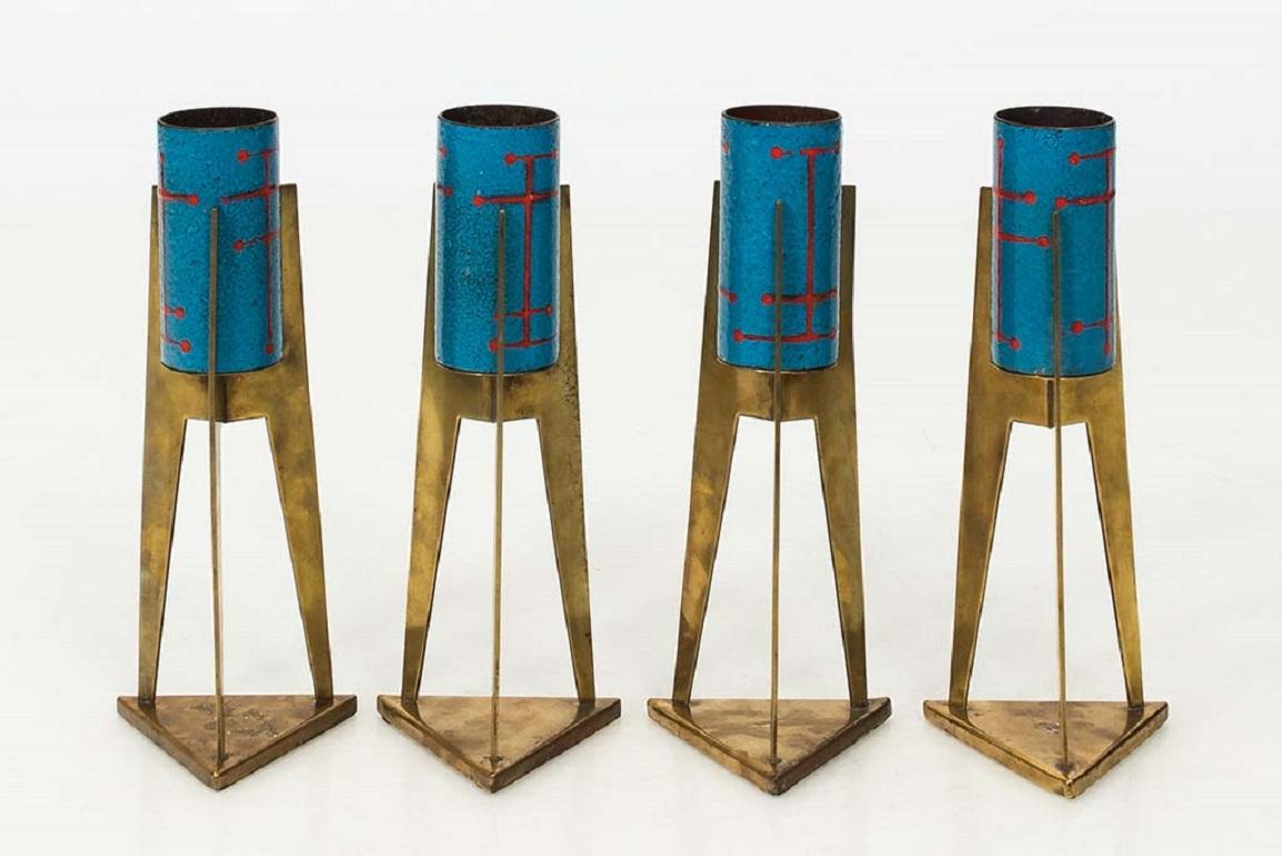 Ensemble de quatre votives modernistes italiennes en laiton et émail dans une finition peinte en bleu et rouge, vers les années 1970.